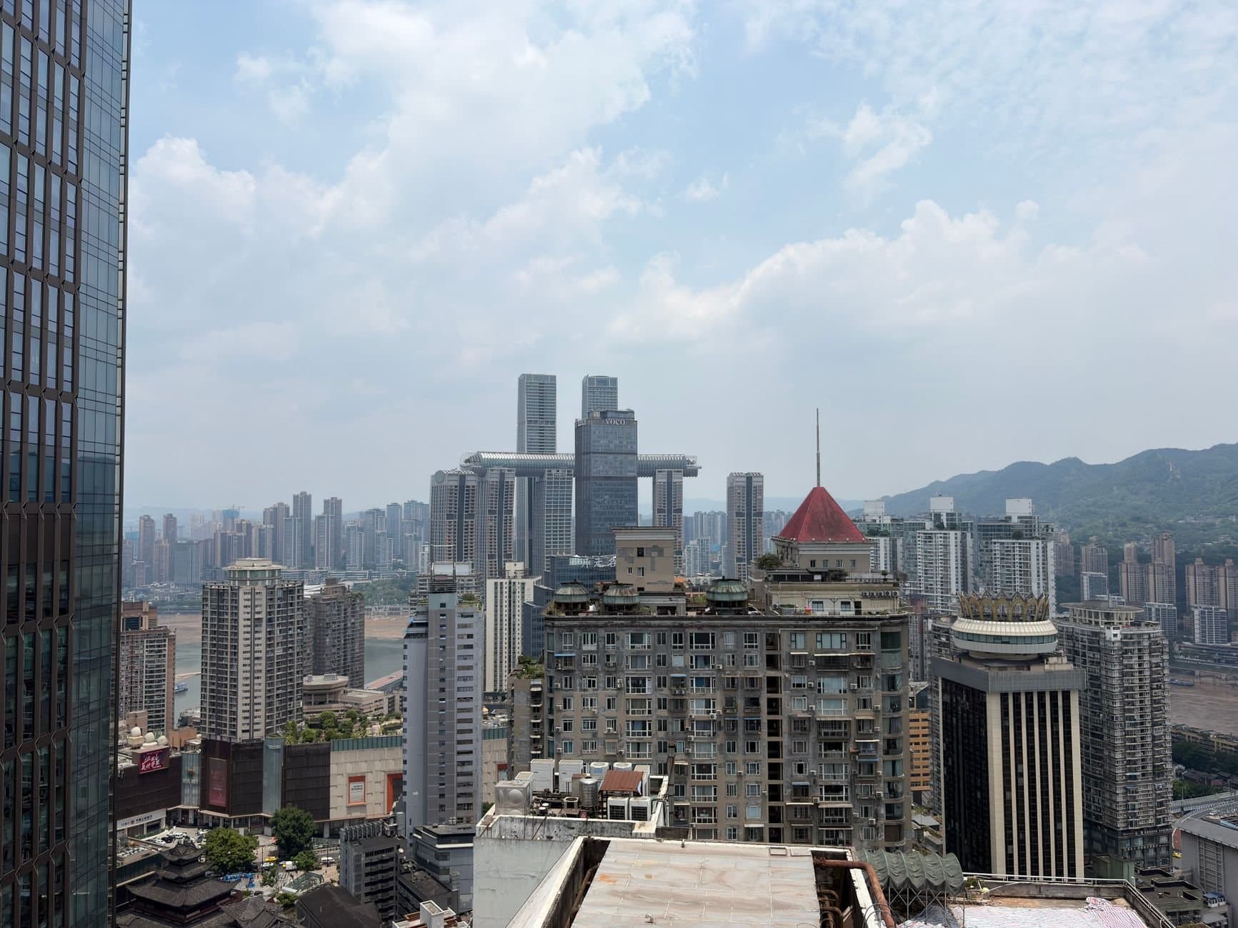 View of Chongqing, China skyline featuring modern architecture under a cloudy sky.