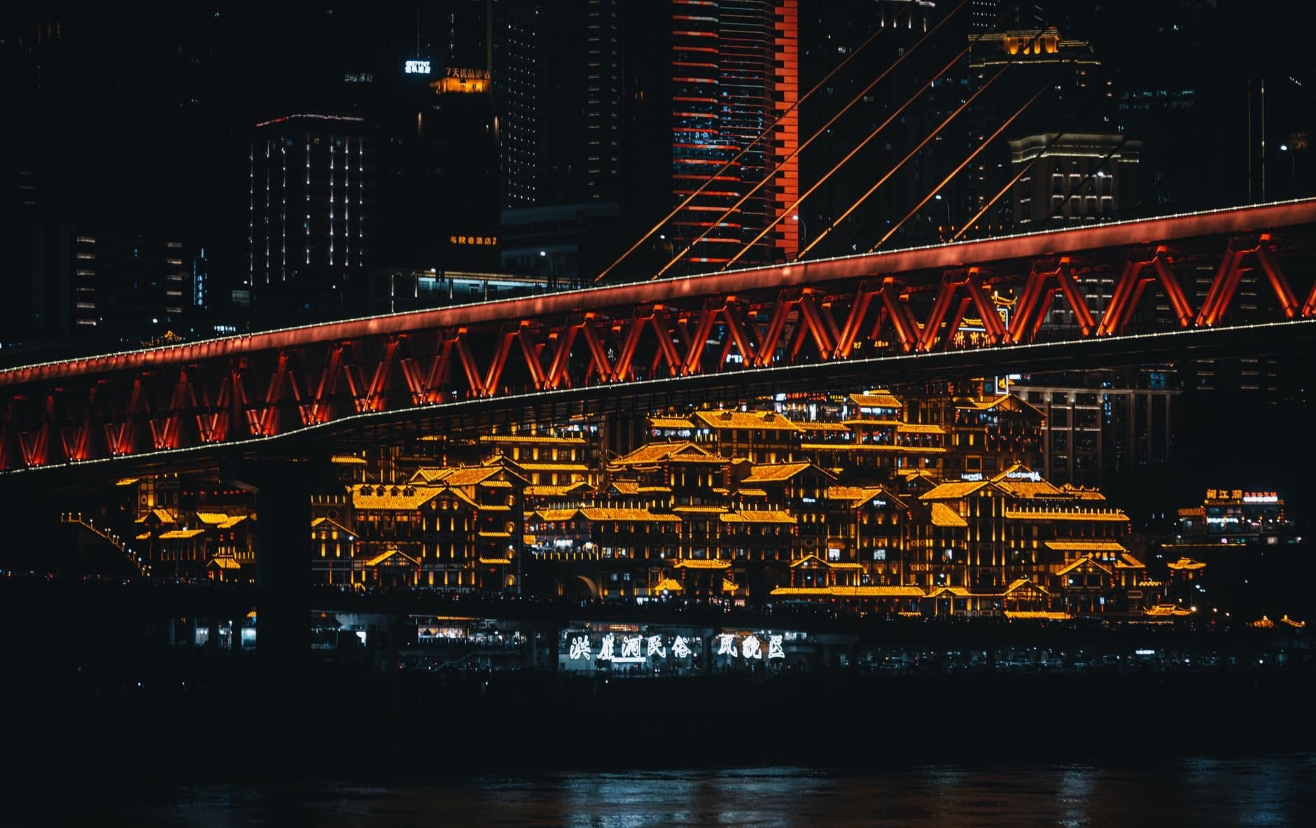 Stunning night scene of Chongqing's illuminated skyline featuring Qiansimen Bridge.