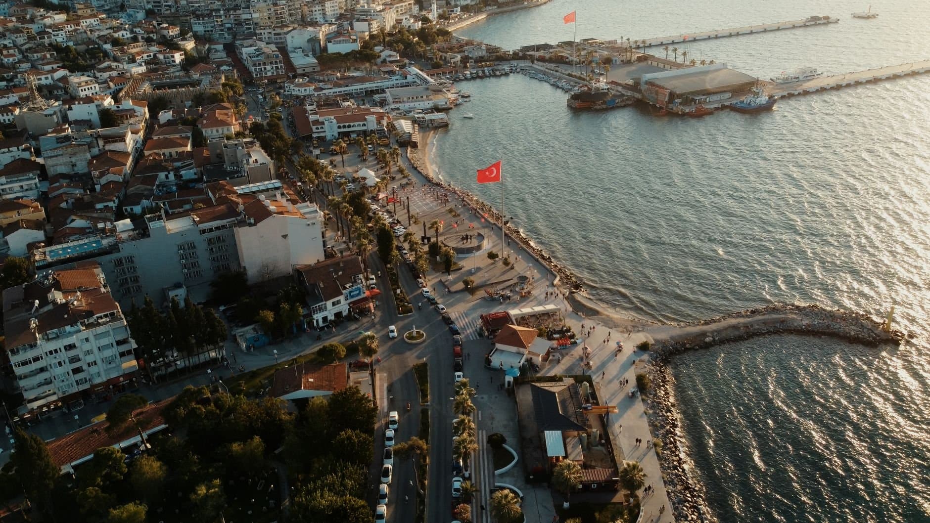 Captivating aerial shot of Kuşadası harbor, showcasing the waterfront and cityscape at sunset.