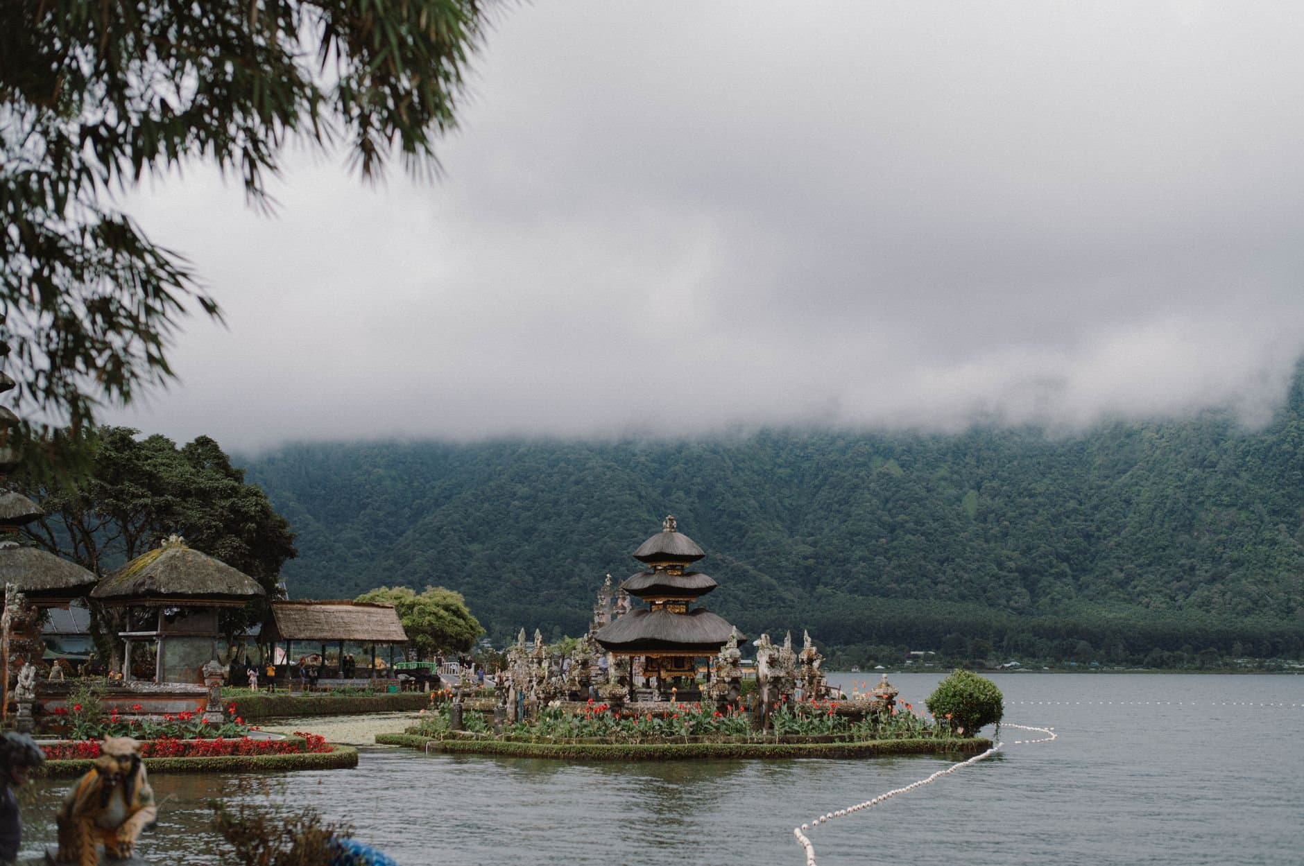 A serene view of the Ulun Danu Beratan Temple surrounded by misty mountains and Lake Beratan.