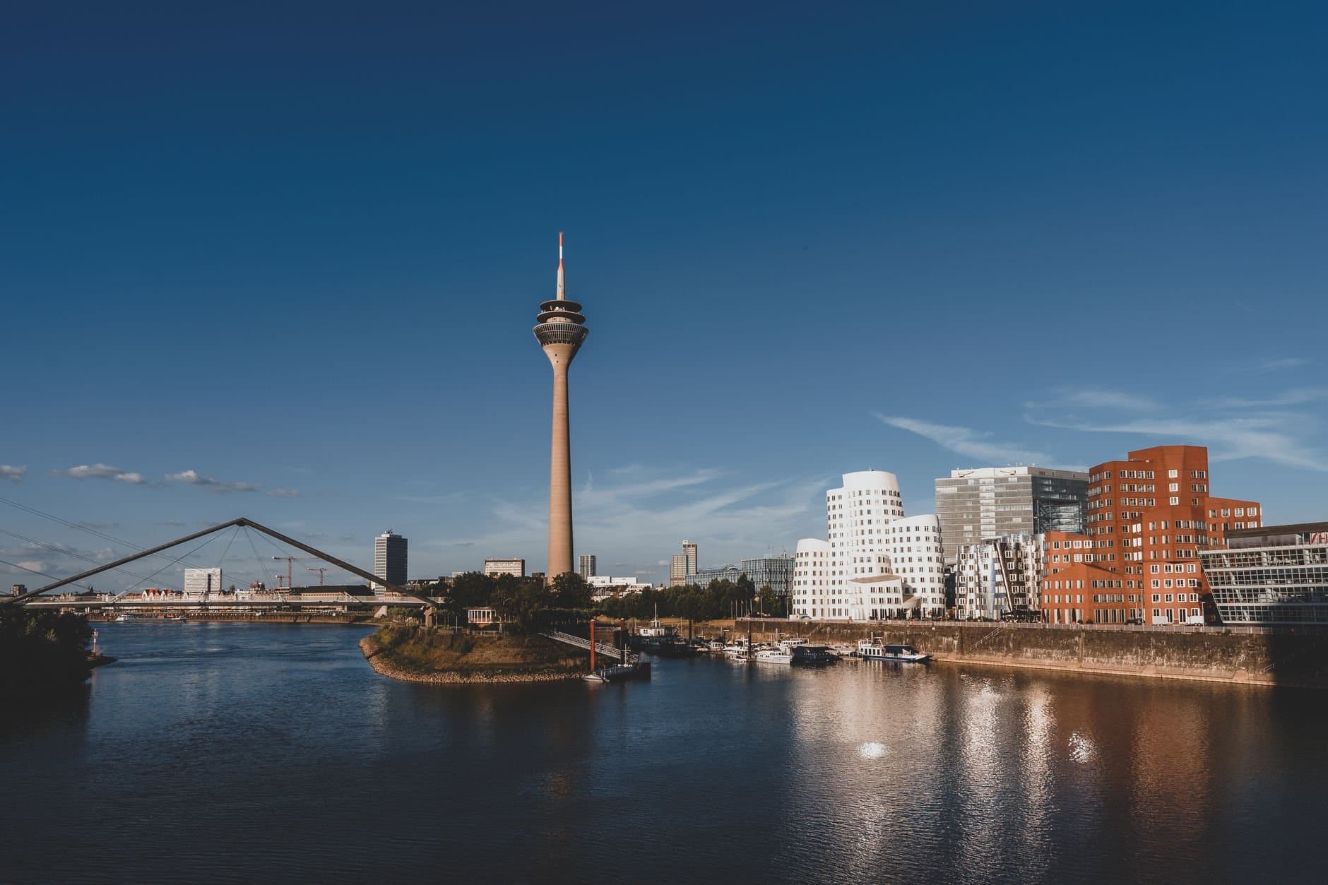 Stunning view of Düsseldorf with Rheinturm and modern architecture reflected in the Rhine River.