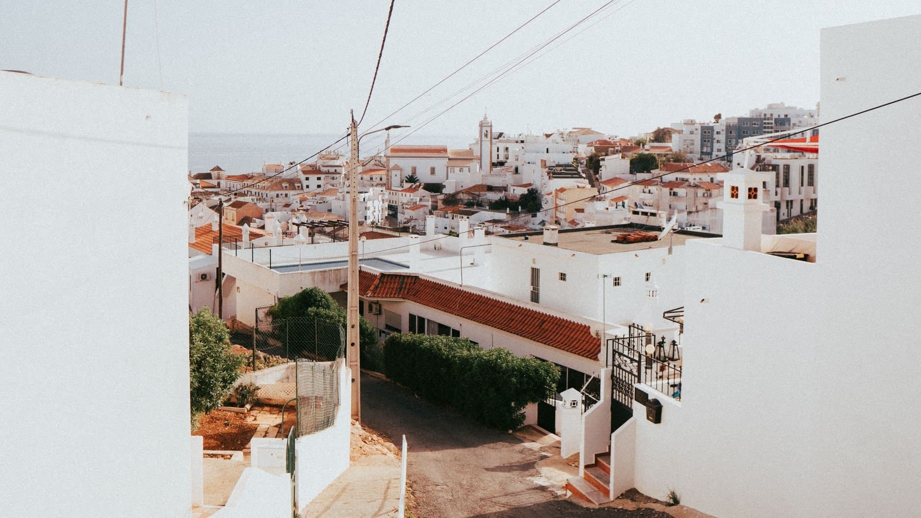 Scenic hillside view of Albufeira's white buildings basking in summer sunlight, Portugal.