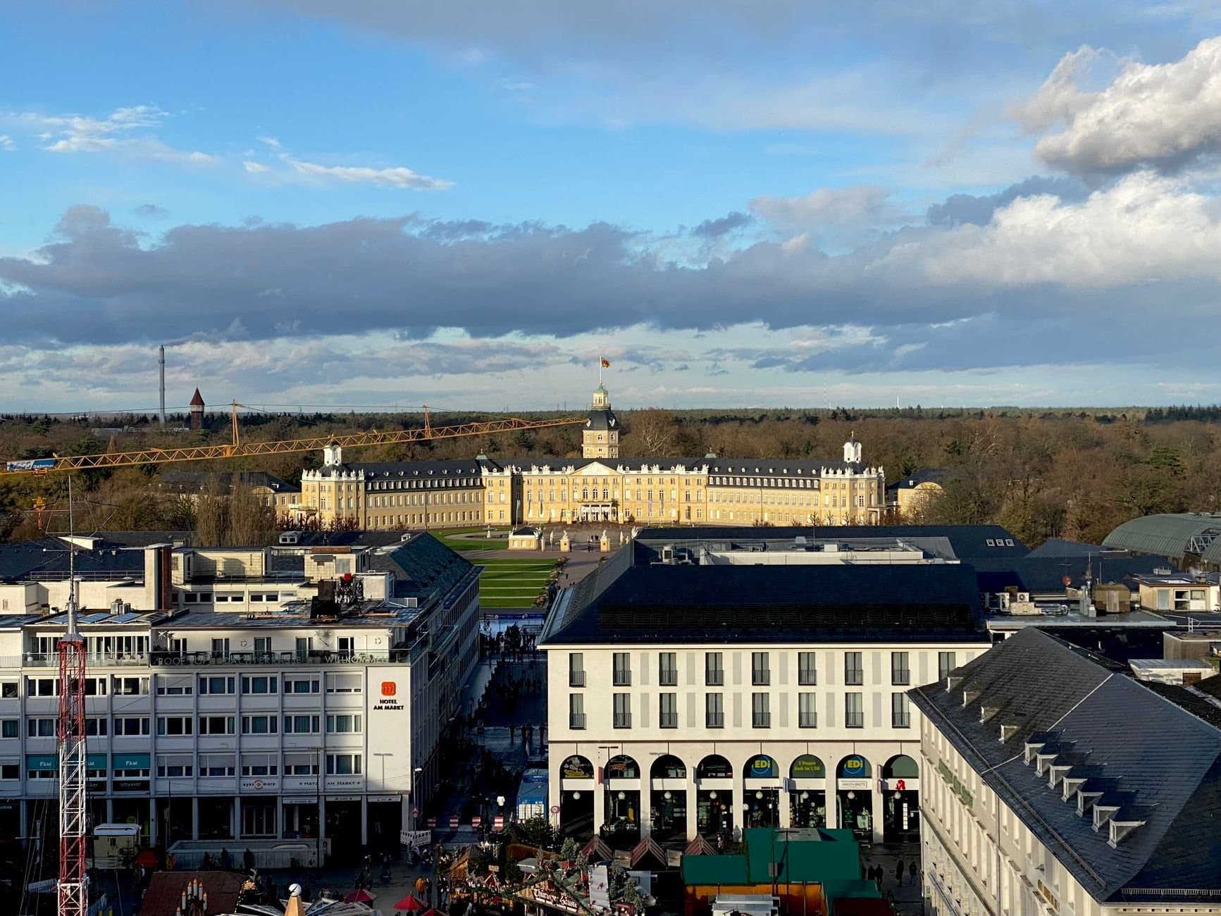 Aerial view of Karlsruhe Palace surrounded by city architecture and trees.