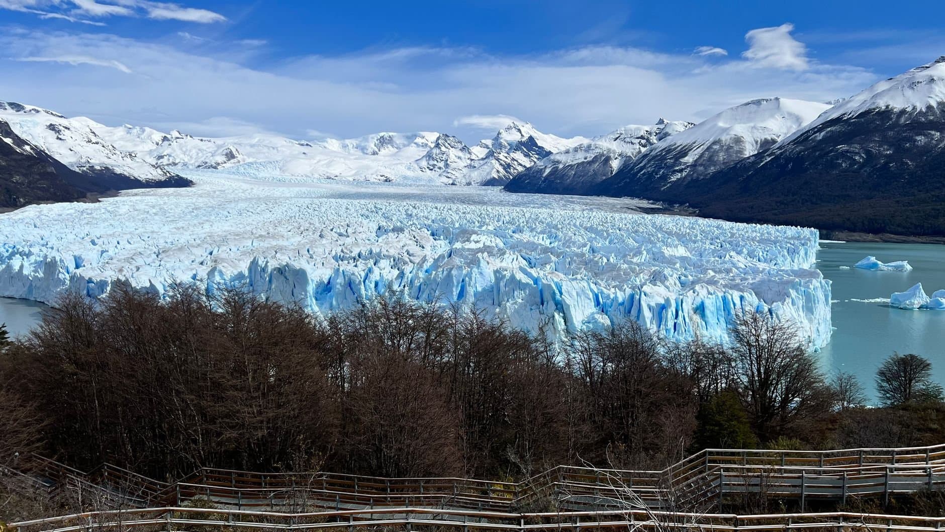Stunning landscape of Perito Moreno Glacier with snowcapped mountains and trees in Argentina.