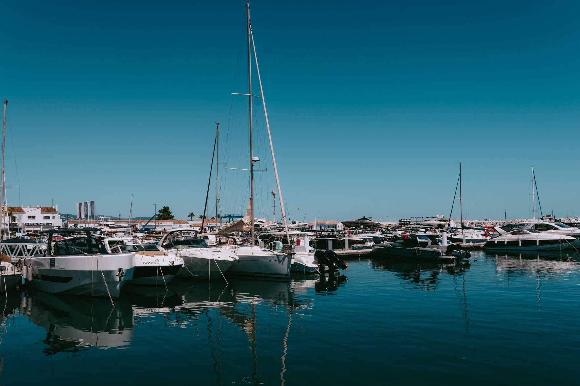 Explore the luxurious yachts and boats at Puerto Banus Marina, Marbella, on a sunny day.