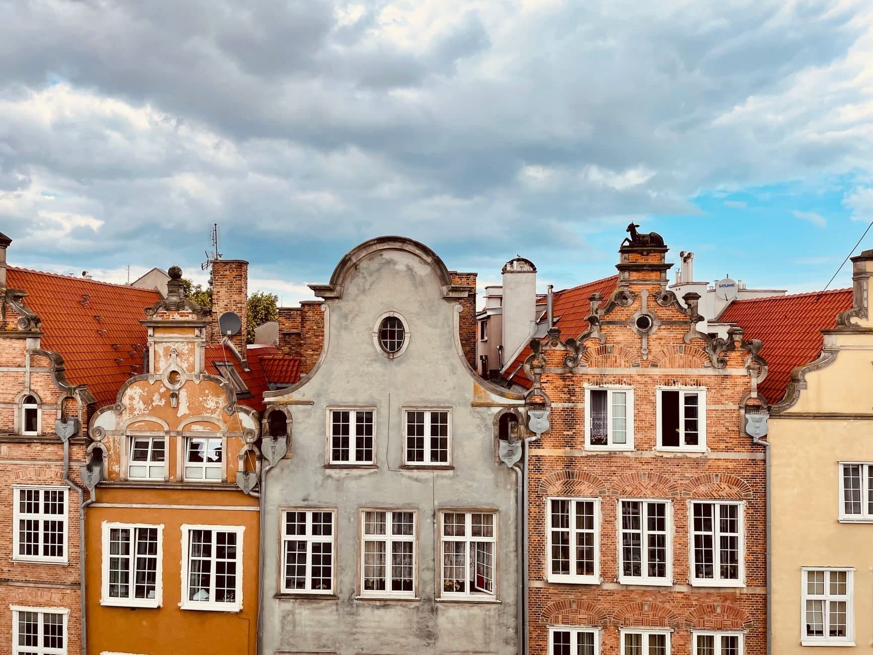 Charming historic buildings in Gdańsk, Poland against an overcast sky.