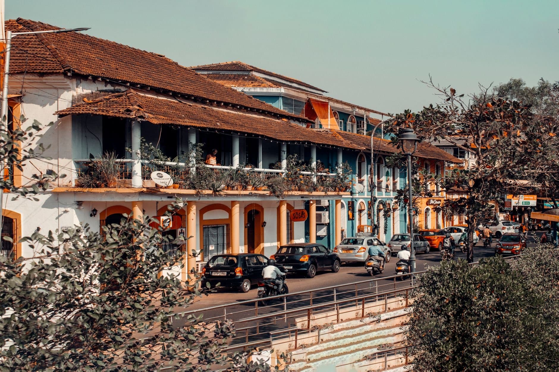 Vibrant street view in Panaji, India showcasing colorful colonial architecture and bustling traffic.
