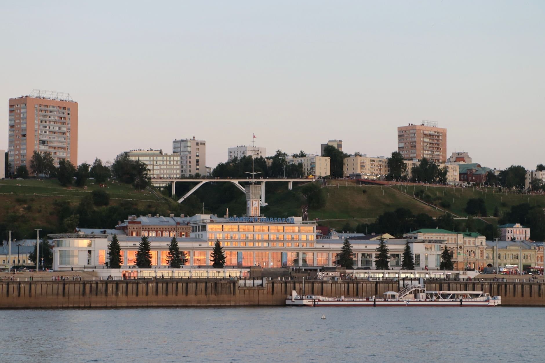 A beautiful riverfront cityscape with buildings and a boat at sunset, capturing urban charm.