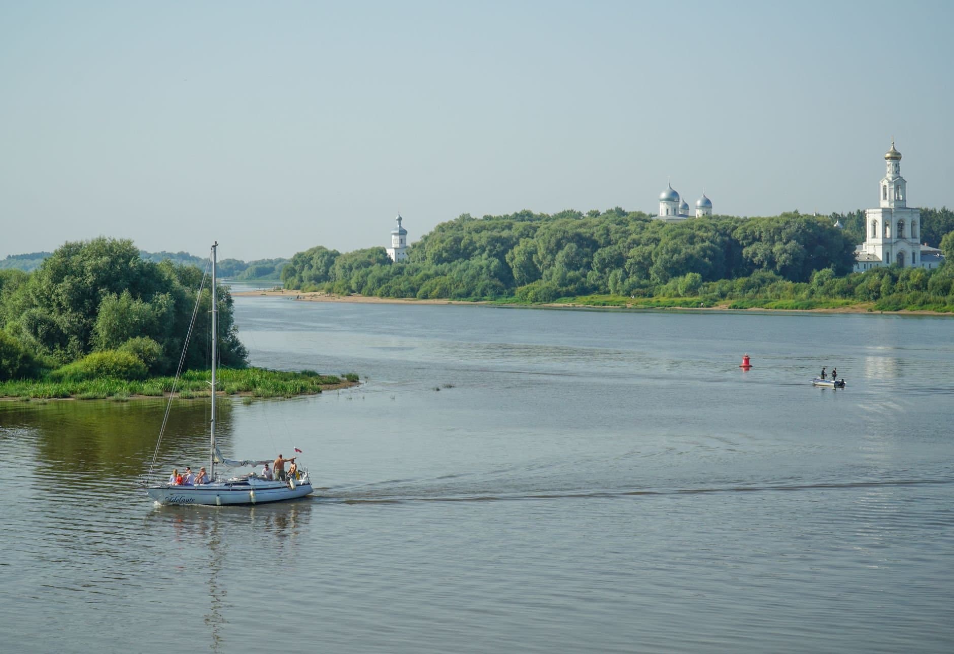 Sailboat cruising along the tranquil Volkhov River in Veliky Novgorod, Russia.