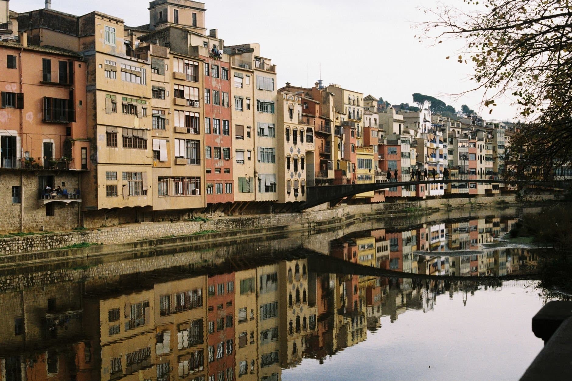 Vibrant historical buildings reflecting in the river in Girona, Catalunya.