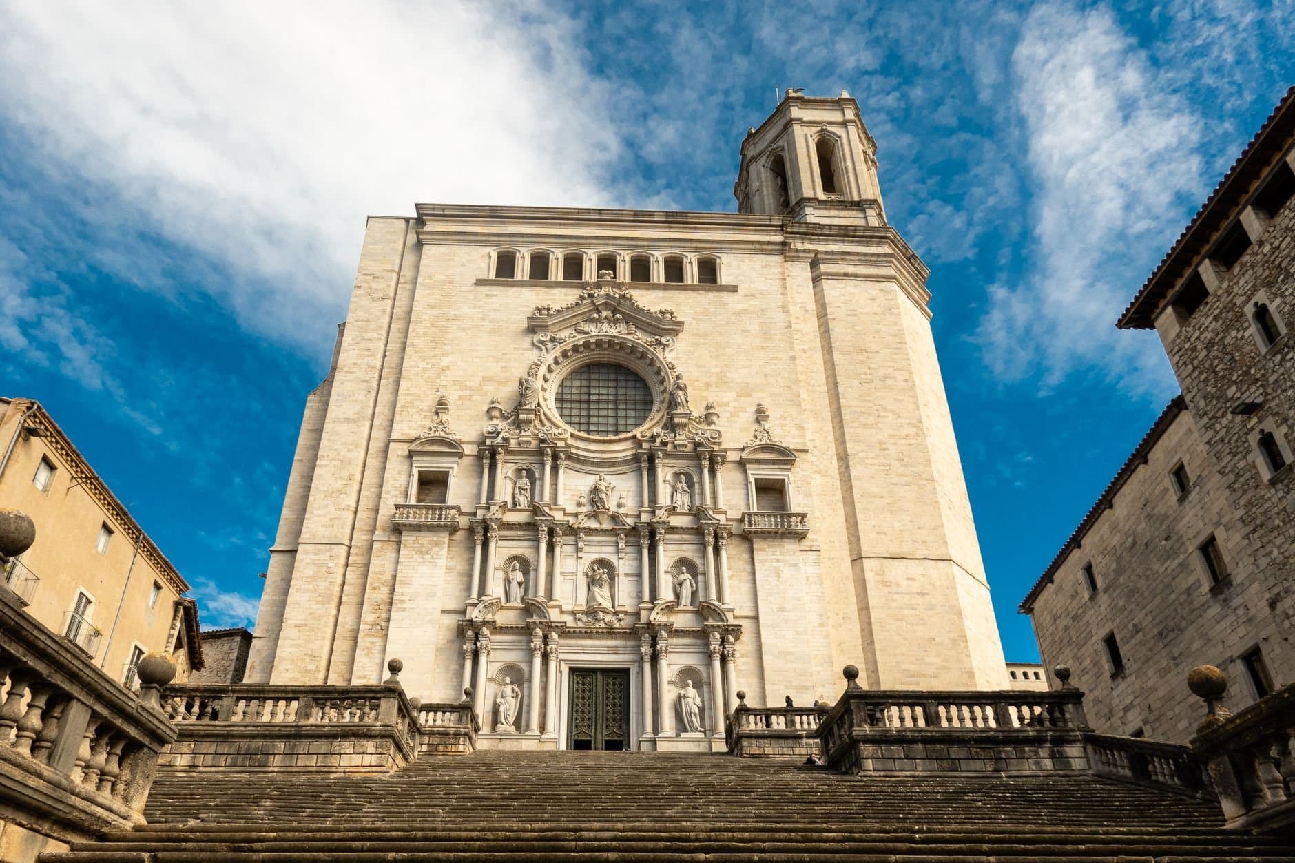 Front view of the iconic Cathedral of Girona against a clear blue sky.