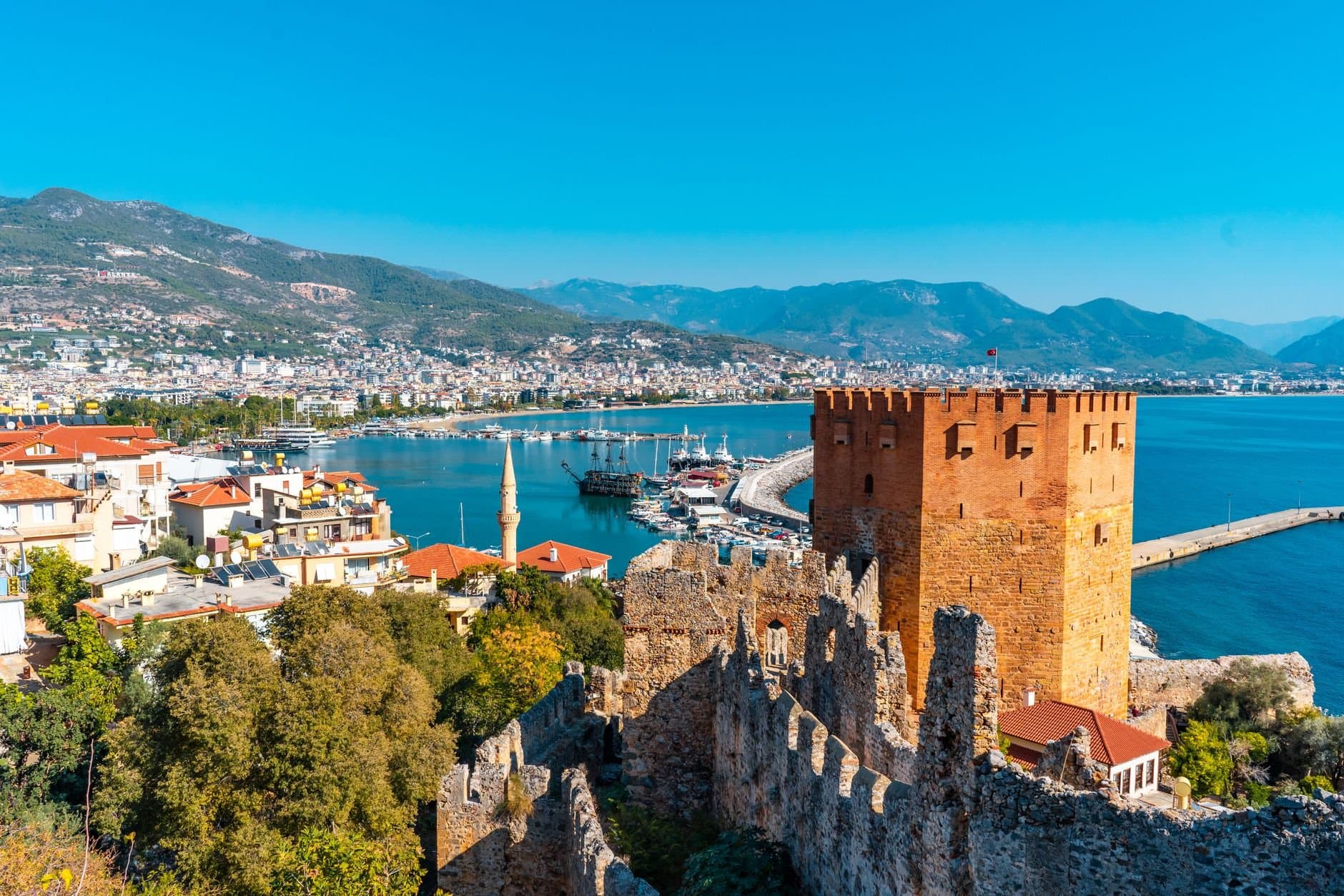 Stunning view of Kizil Kule and Alanya harbor in Antalya, Turkey with vibrant city and sea landscape.