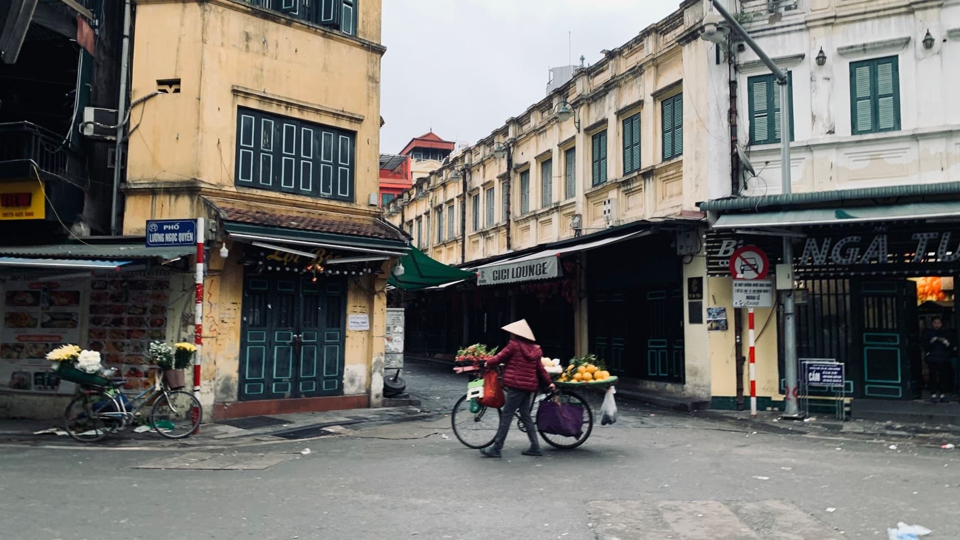 Street vendor with a bicycle in the urban market of Hanoi, Vietnam.