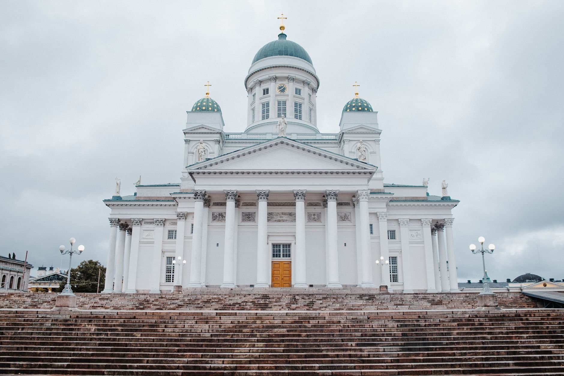 A frontal view of the iconic Helsinki Cathedral featuring neoclassical architecture under a cloudy sky.