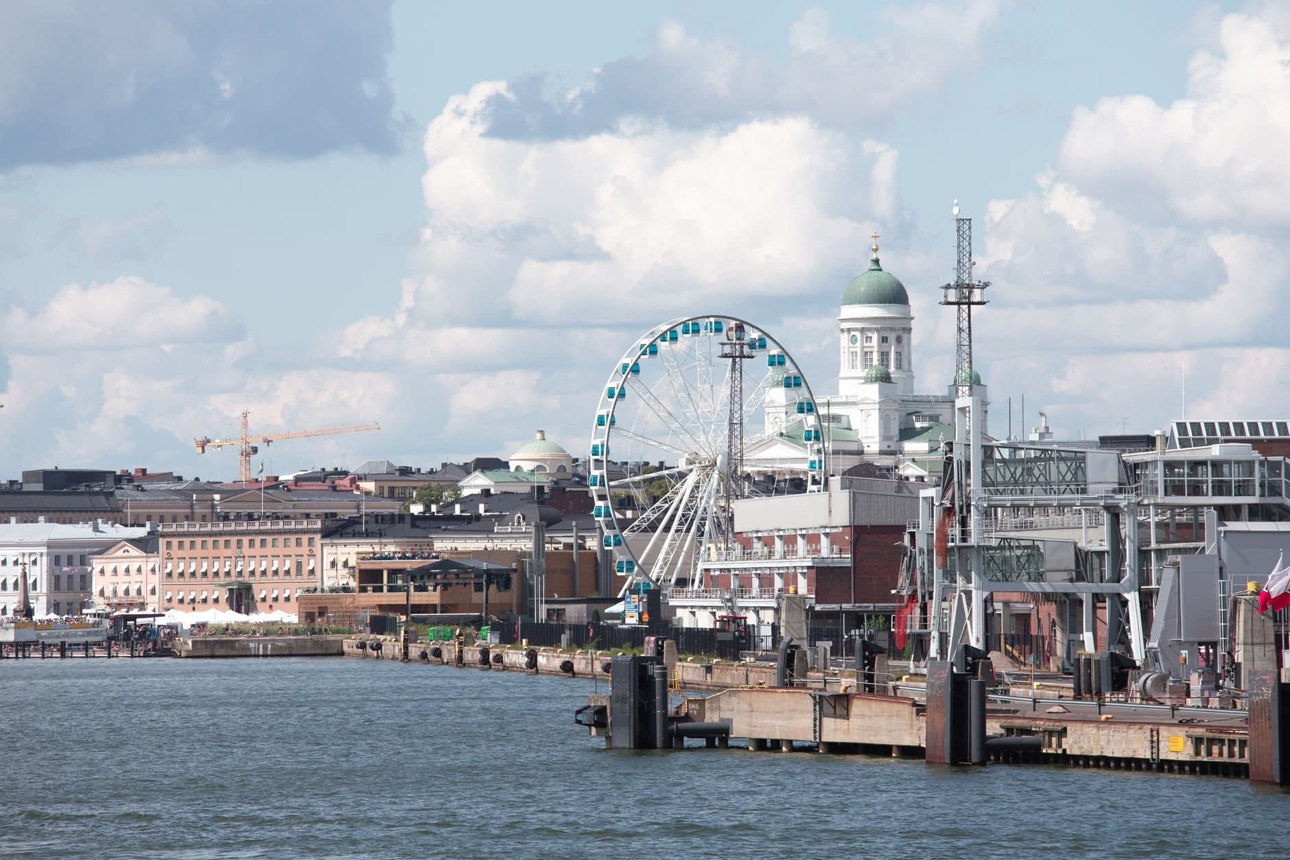 Scenic Helsinki waterfront featuring the Sky Wheel and iconic Helsinki Cathedral.