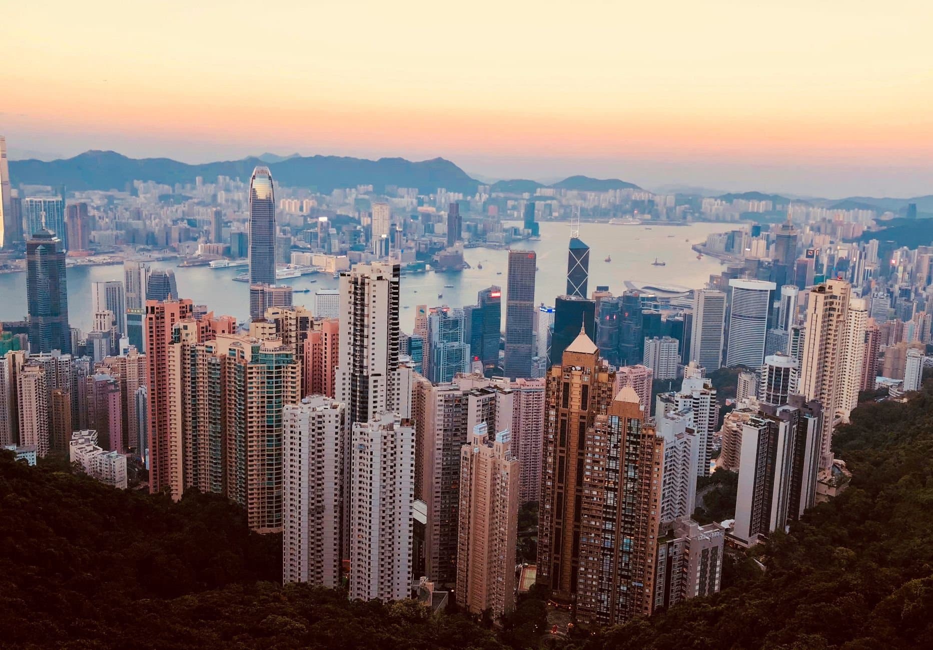 Breathtaking Kowloon skyline with skyscrapers and harbor at sunset, showcasing Hong Kong's urban beauty.