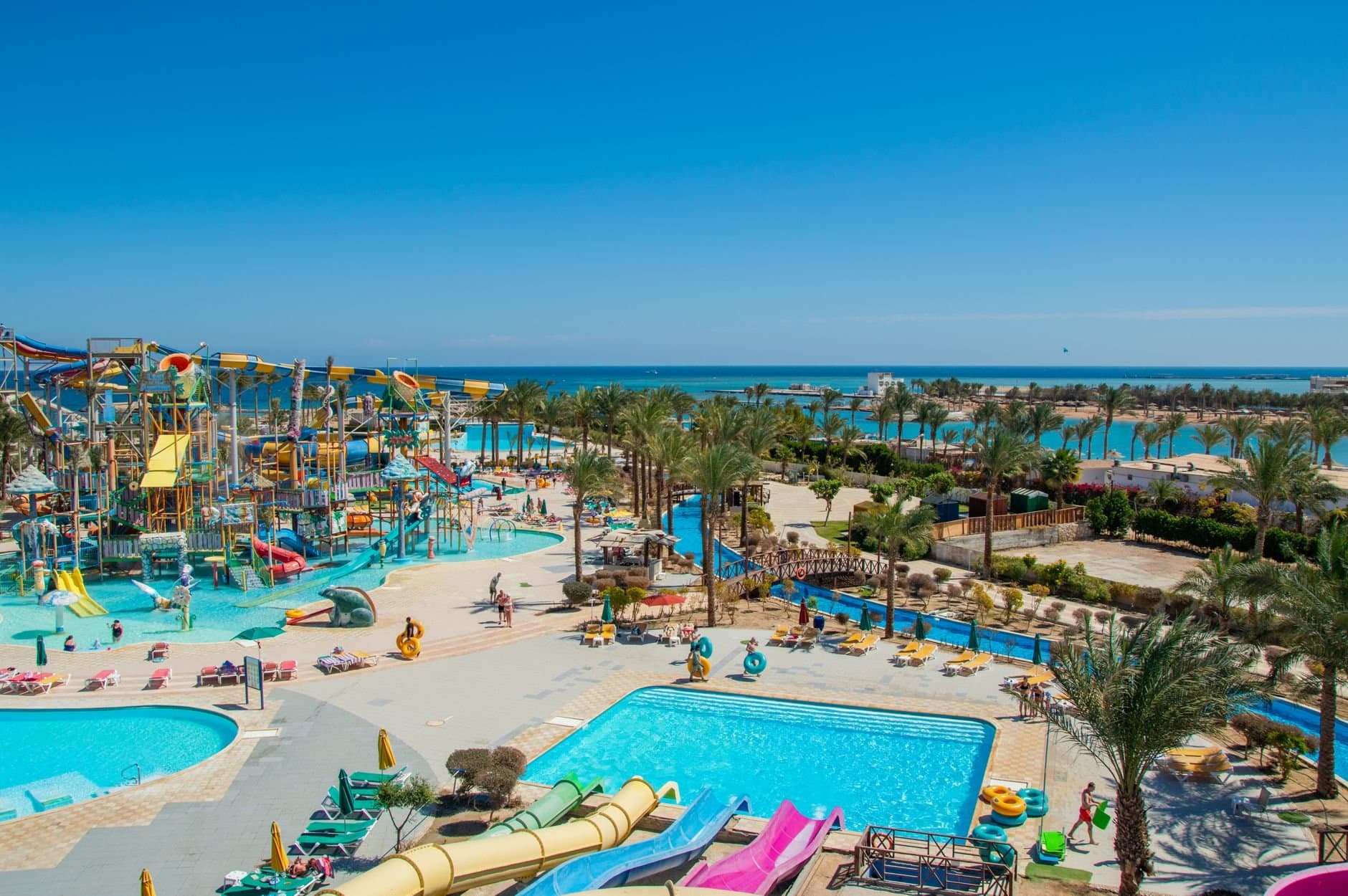 Aerial view of a lively tropical water park by the sea, perfect for family fun under the sun.