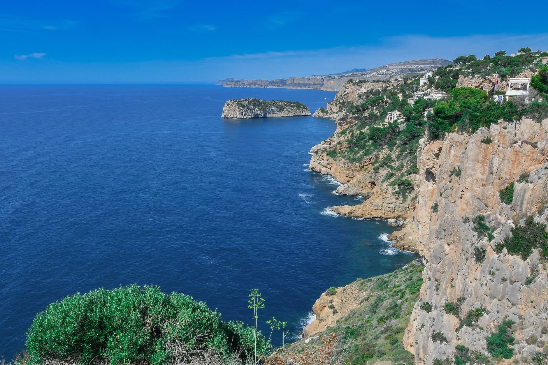 A breathtaking view of the rugged coastal cliffs and blue sea in Jávea, Spain.