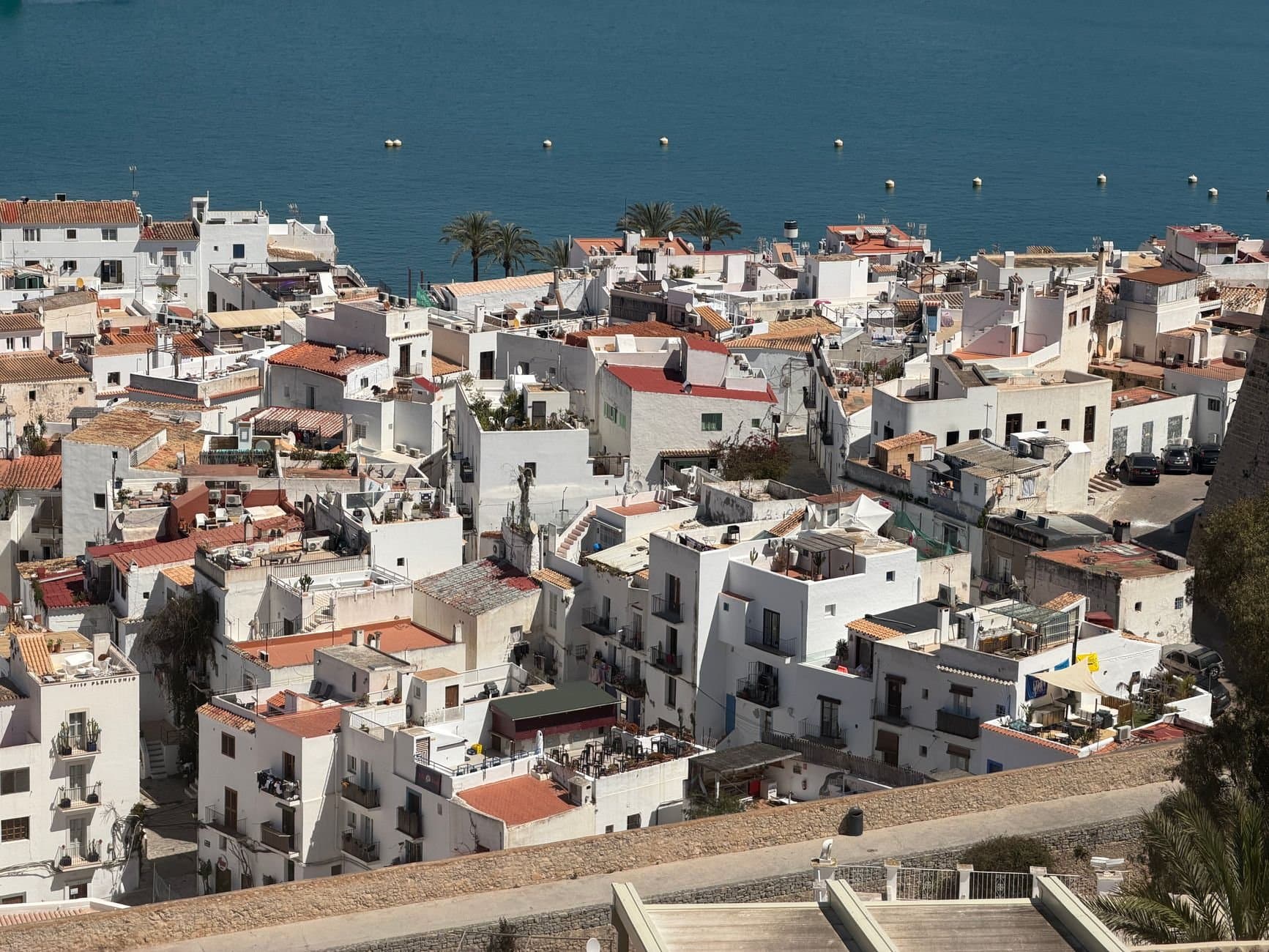 Aerial perspective of the picturesque whitewashed buildings in Eivissa, Ibiza with a stunning sea backdrop.