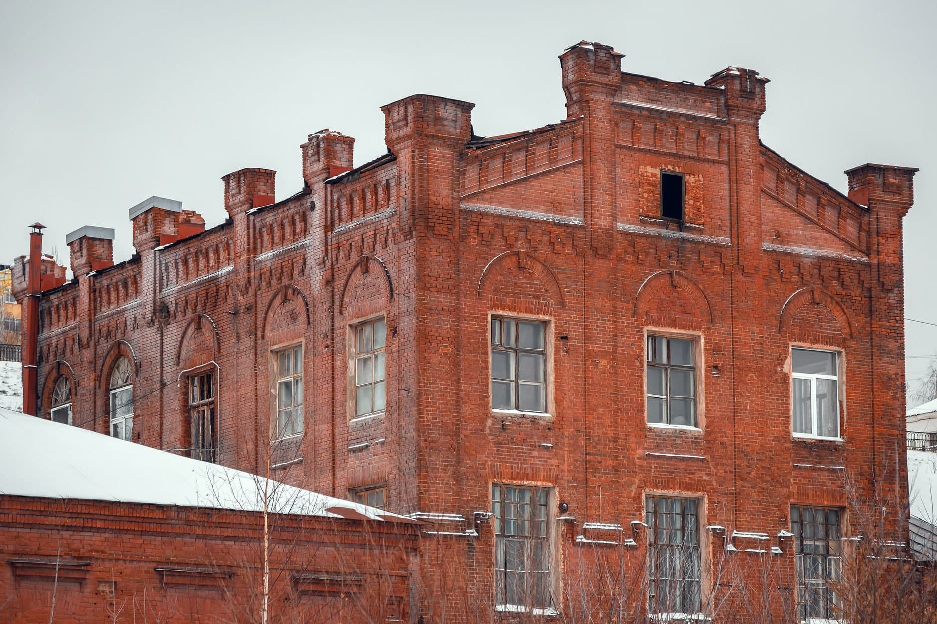 Abandoned brick building in Izhevsk, Udmurtia, showcasing historic architecture in a snowy setting.