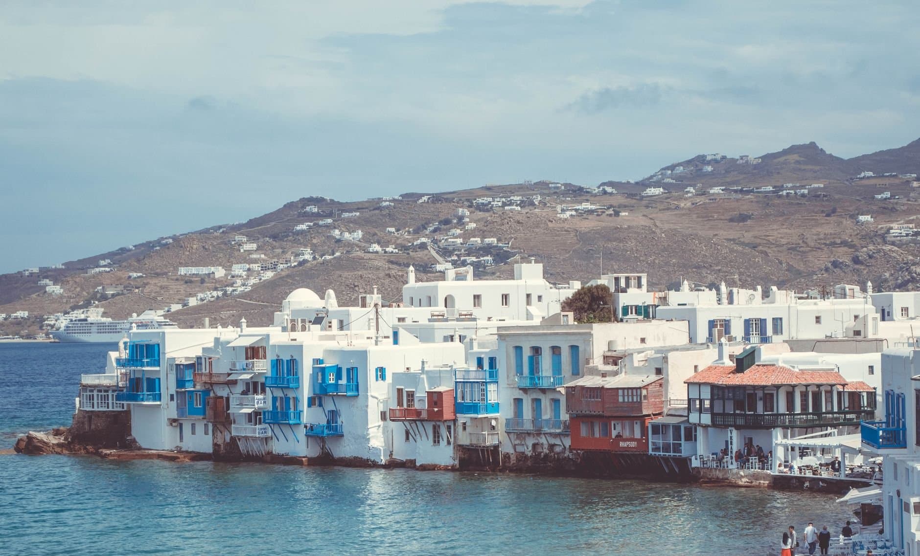 Picturesque waterfront buildings in Mykonos, Greece, showcasing unique Cycladic architecture against the Aegean Sea.