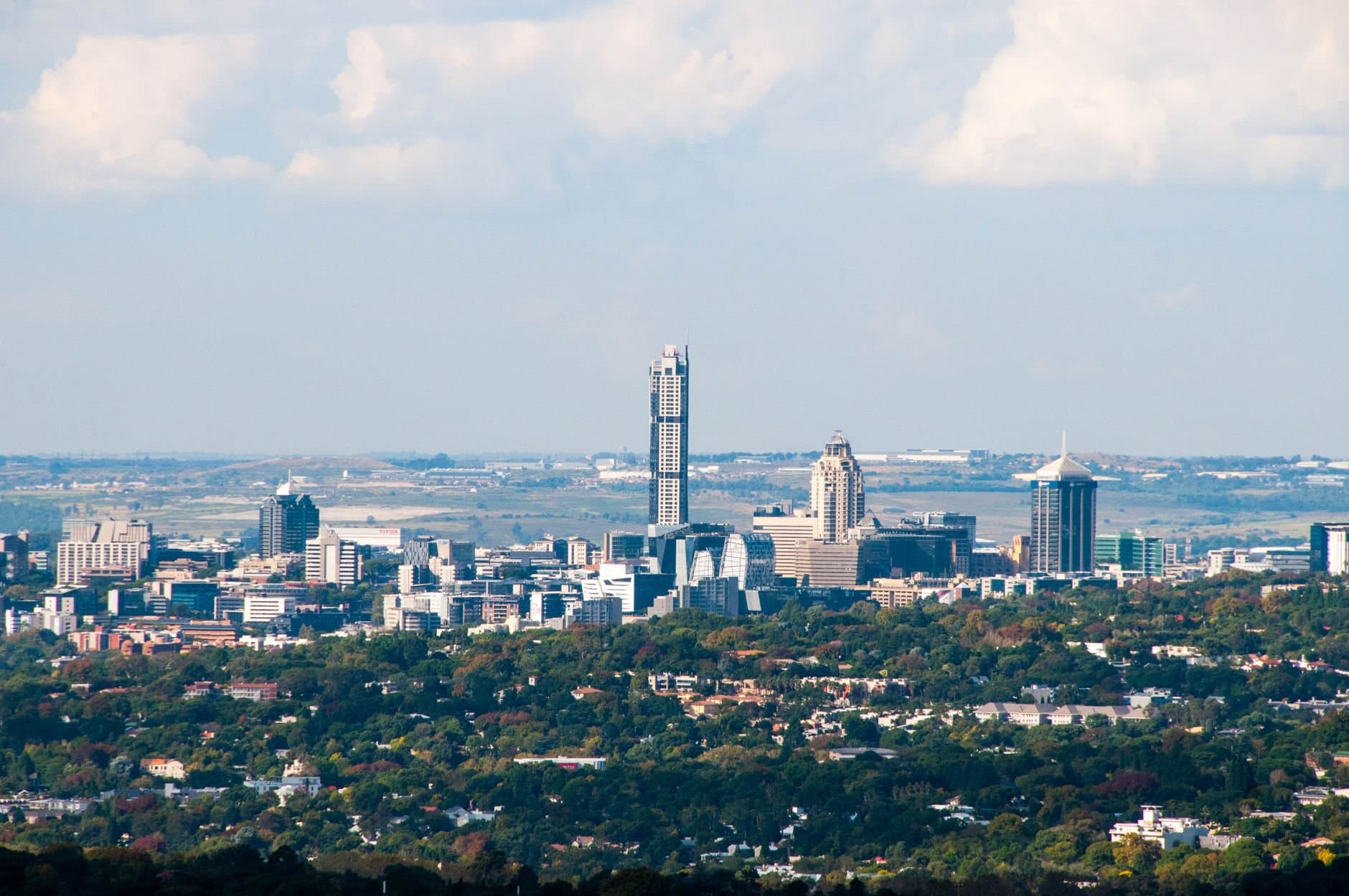 Aerial view of Sandton's skyline in Gauteng, South Africa, with a clear blue sky.