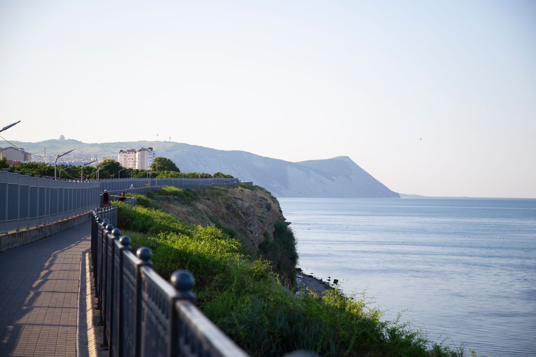 Beautiful seaside promenade with railing in Anapa, offering stunning views of the Black Sea and surrounding cliffs.