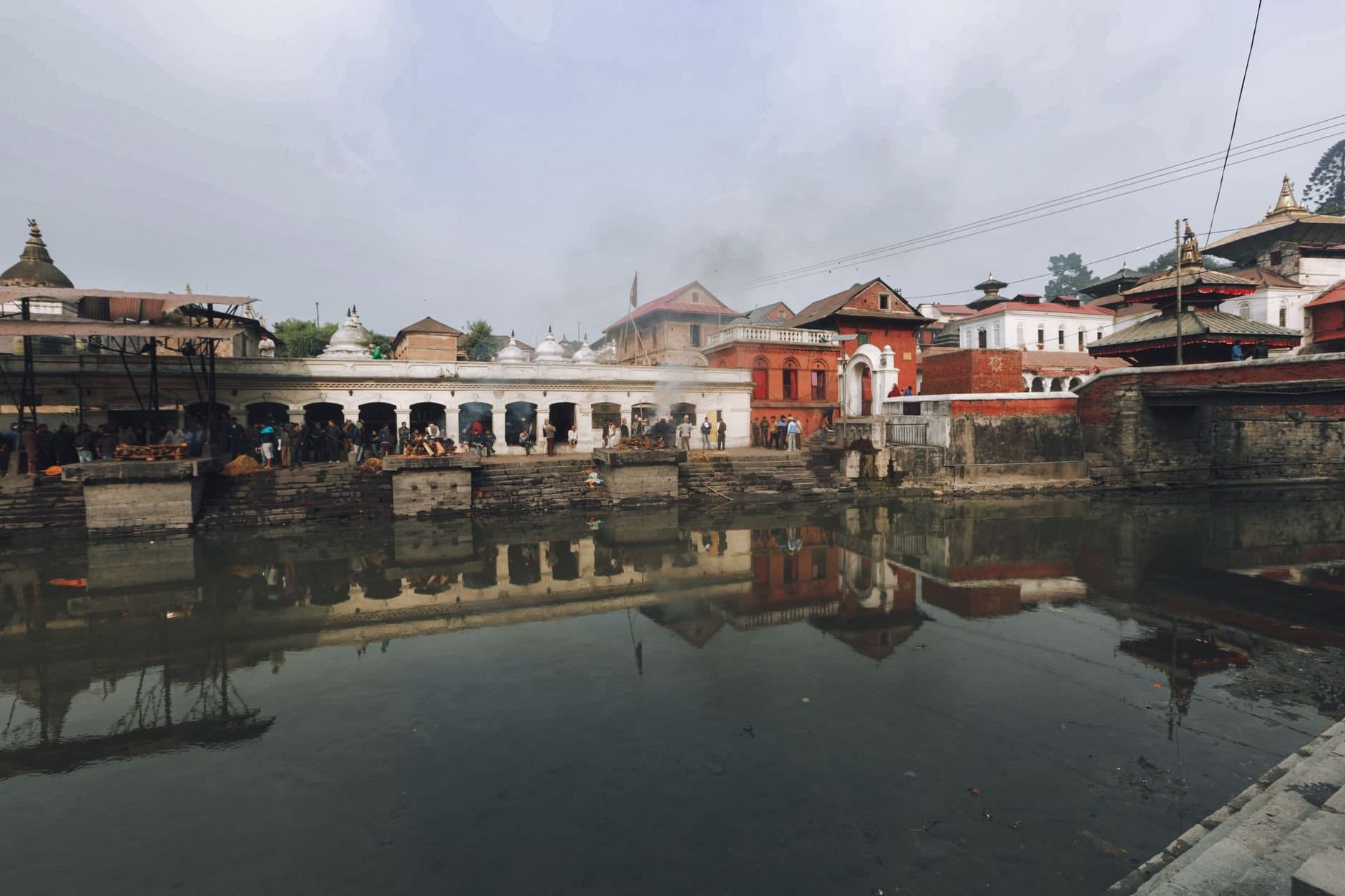 A scenic view of the Pashupatinath Temple with reflections in the Bagmati River.