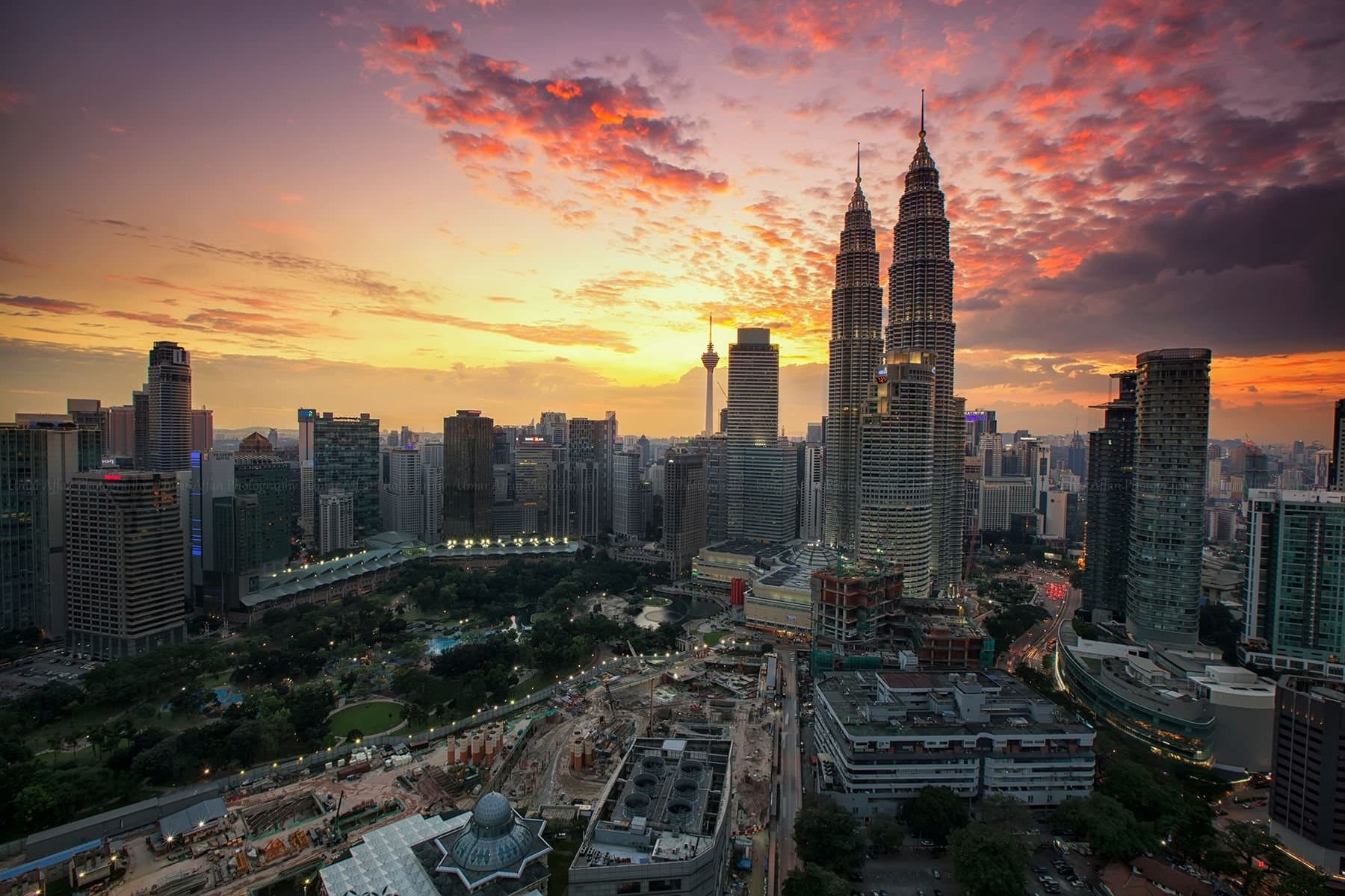A breathtaking view of Kuala Lumpur's skyline featuring the Petronas Twin Towers at sunset.