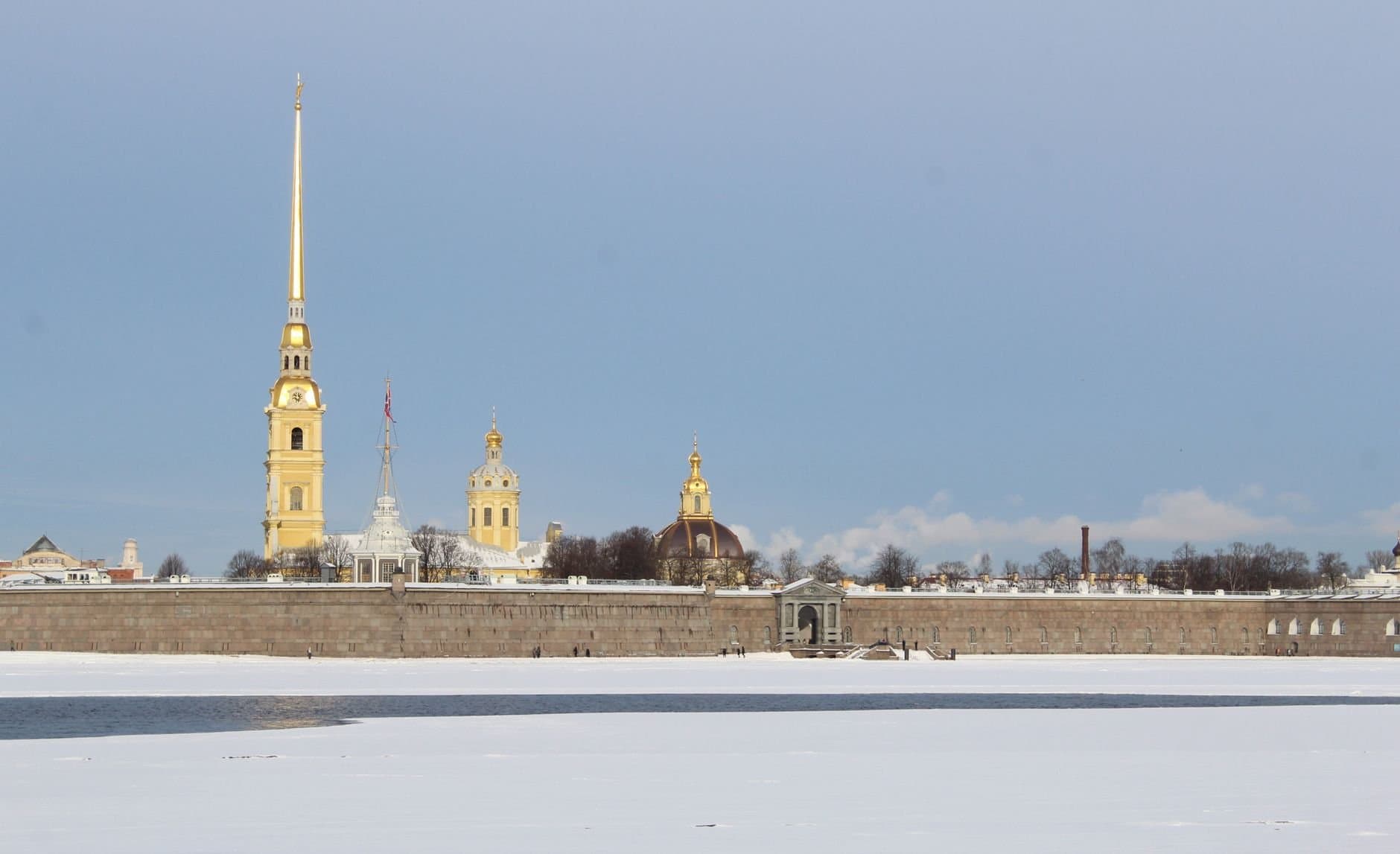 A scenic winter view of Peter and Paul Cathedral in Saint Petersburg with snow-covered landscape.