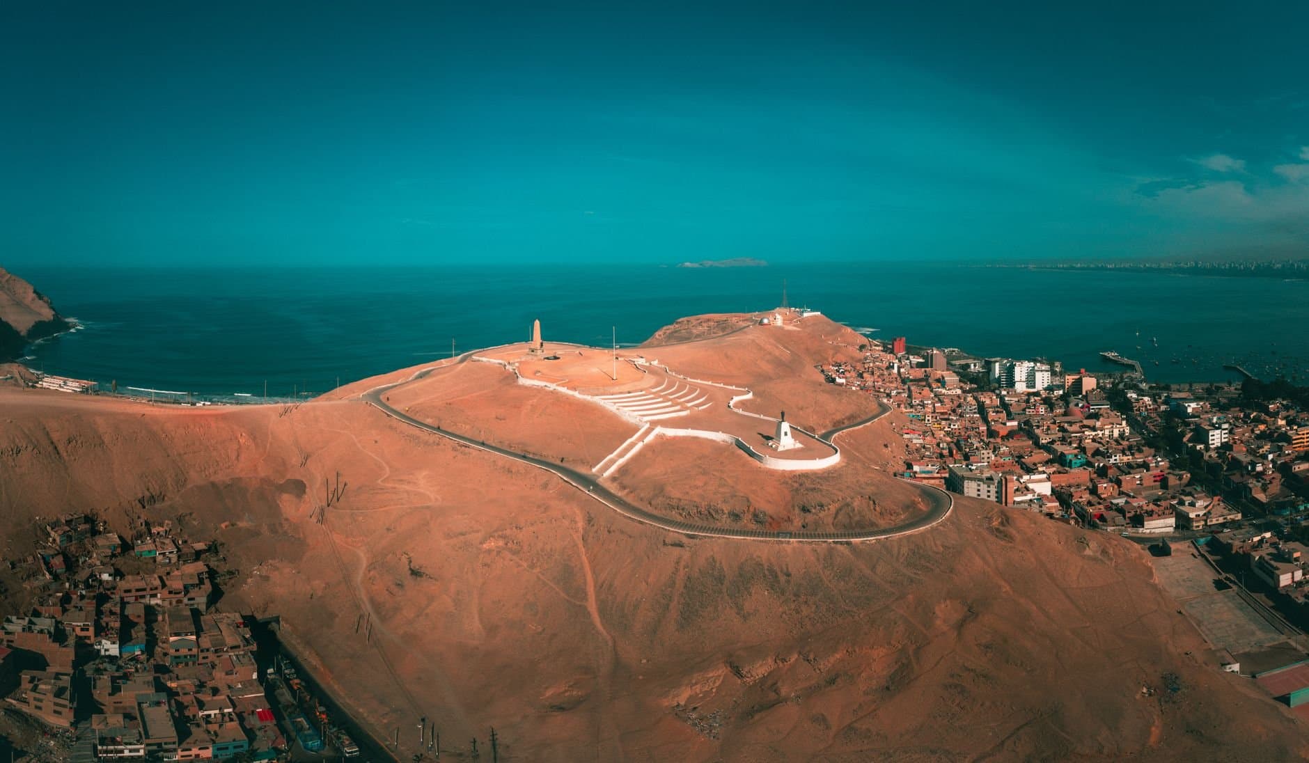 A stunning aerial view of Callao, Peru featuring coastal landscapes, hills, and ocean horizon.