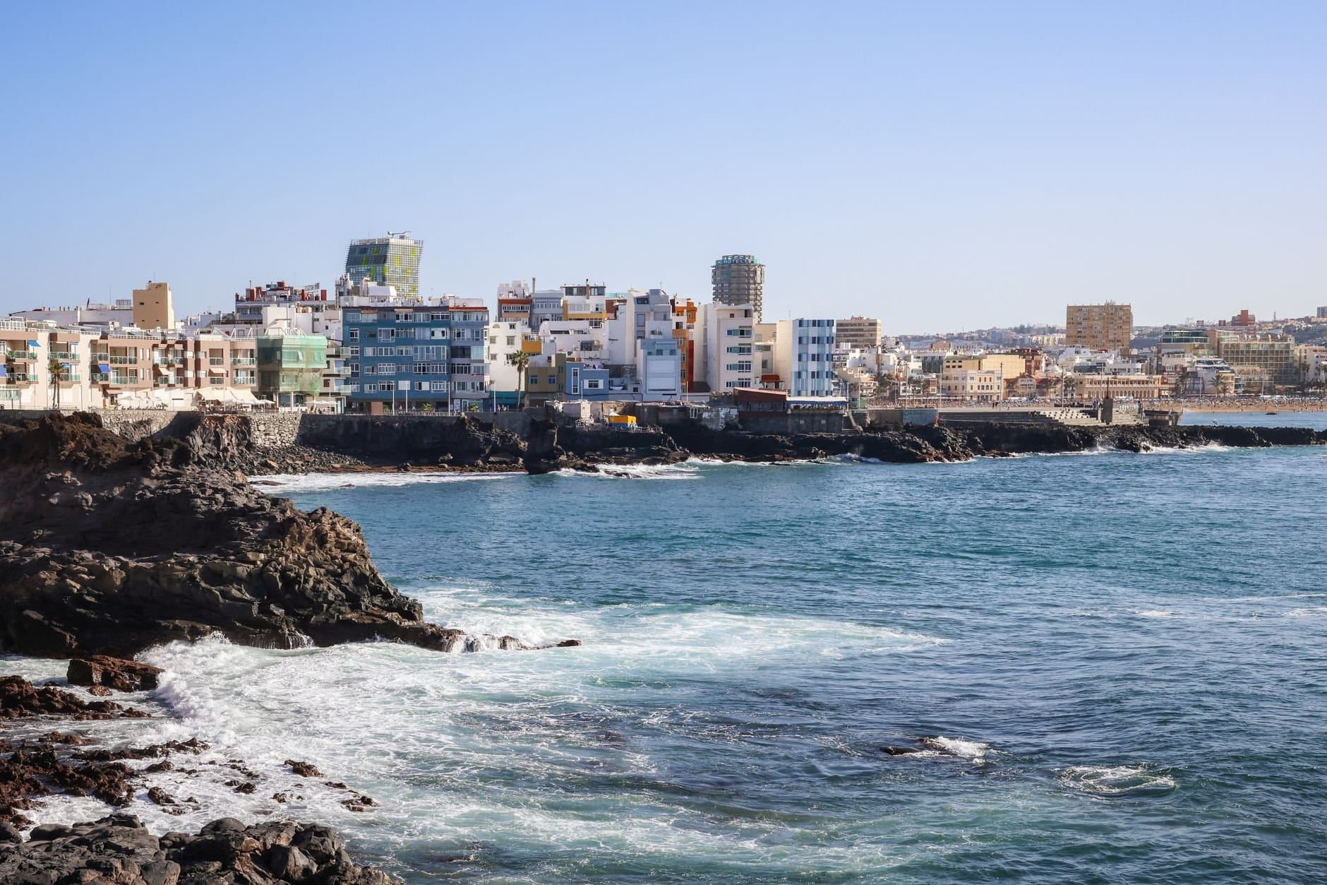 Vibrant cityscape view of Las Palmas de Gran Canaria on a sunny day overlooking the ocean.