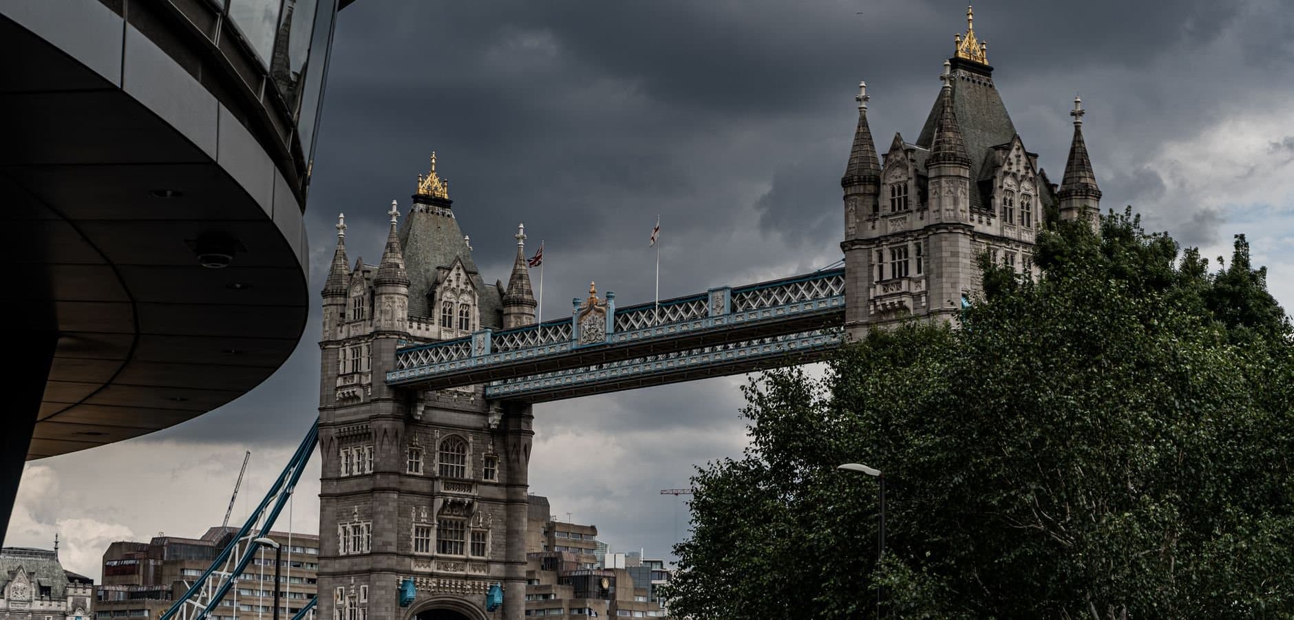 Scenic view of Tower Bridge in London, showcasing its majestic architecture under a dramatic sky.