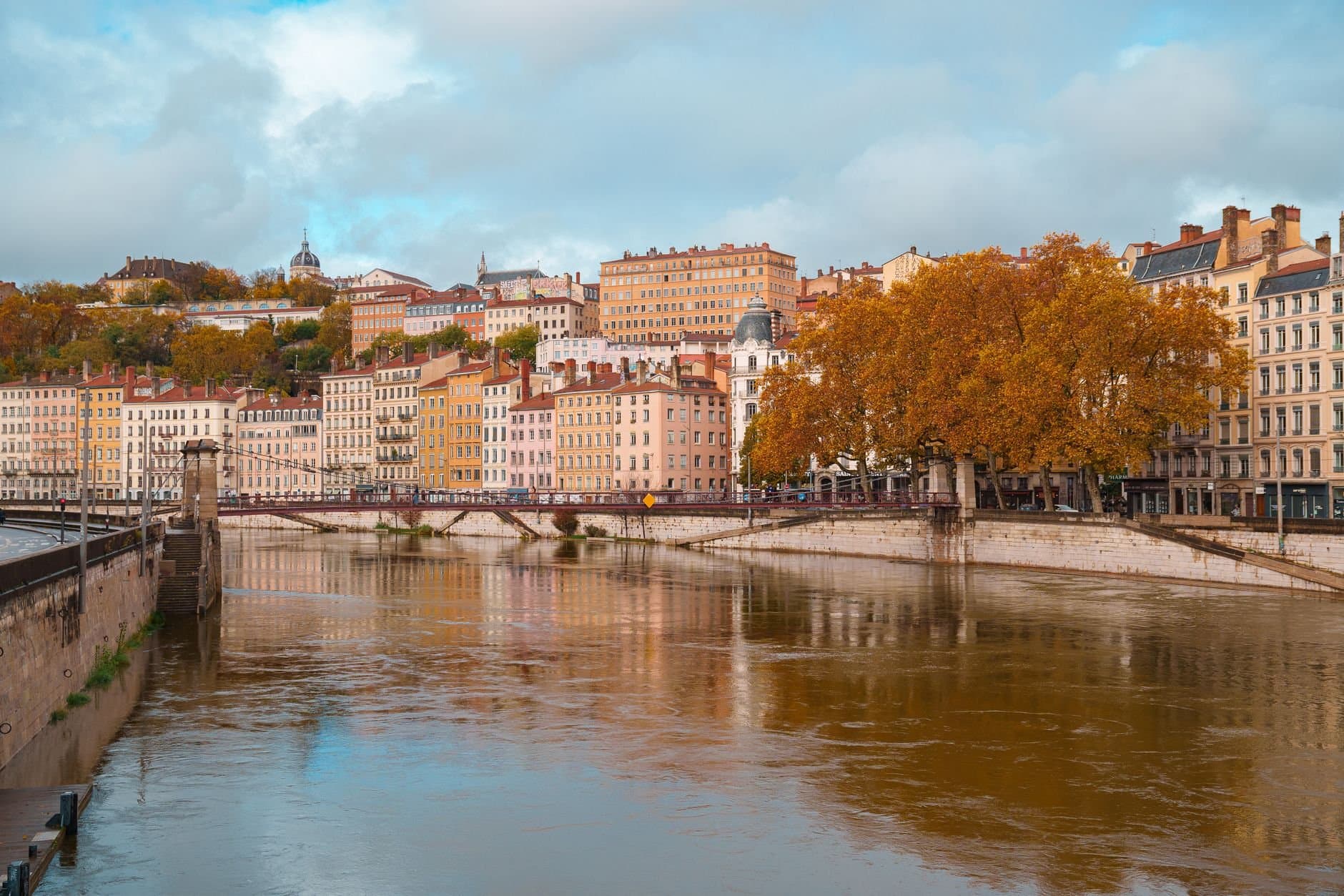 Beautiful autumn scene of the Saône River and Lyon's architecture in Auvergne-Rhône-Alpes, France.