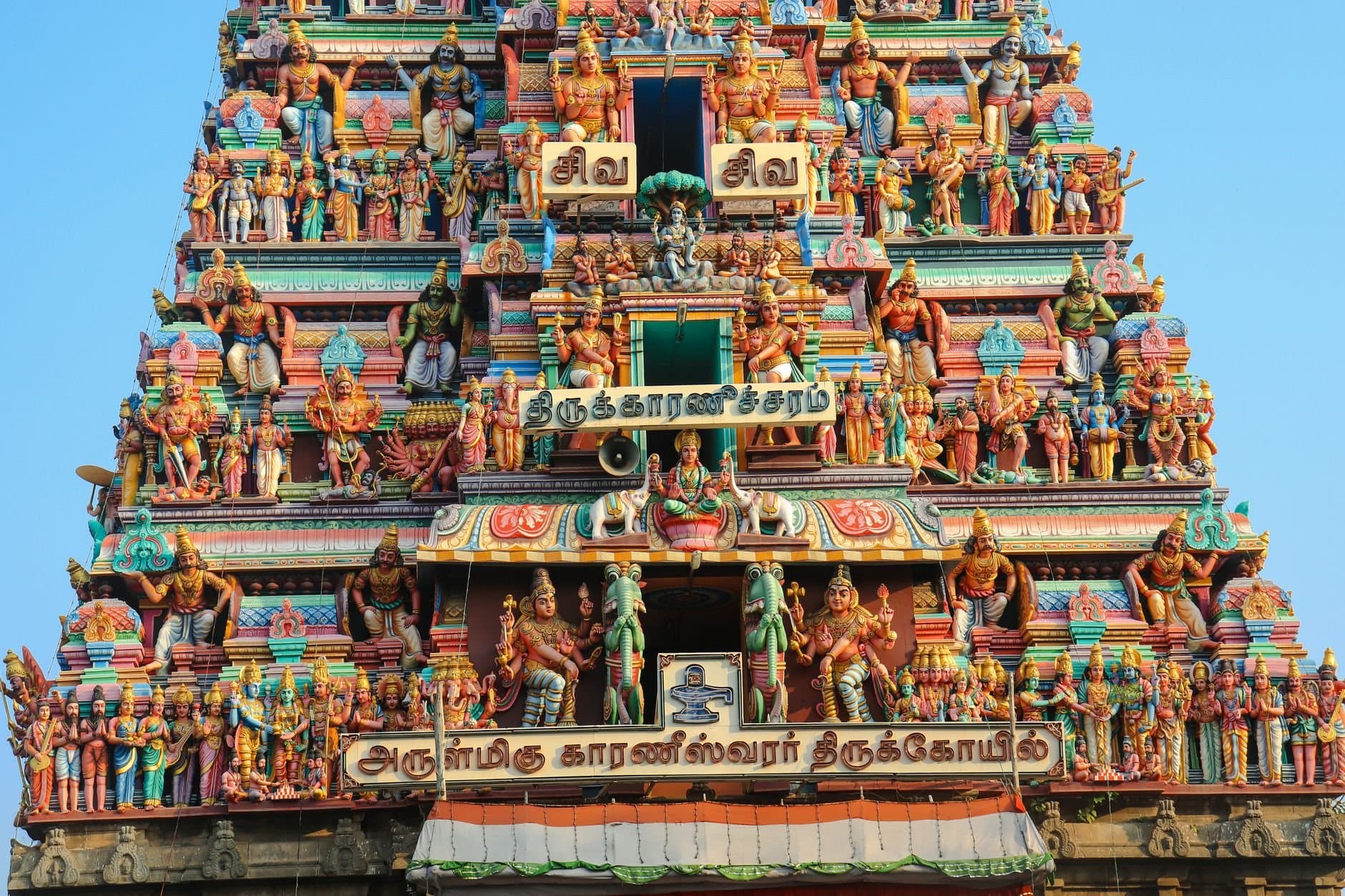 Intricately ornamented facade of a Hindu temple in Chennai, showcasing colorful statues and religious motifs.