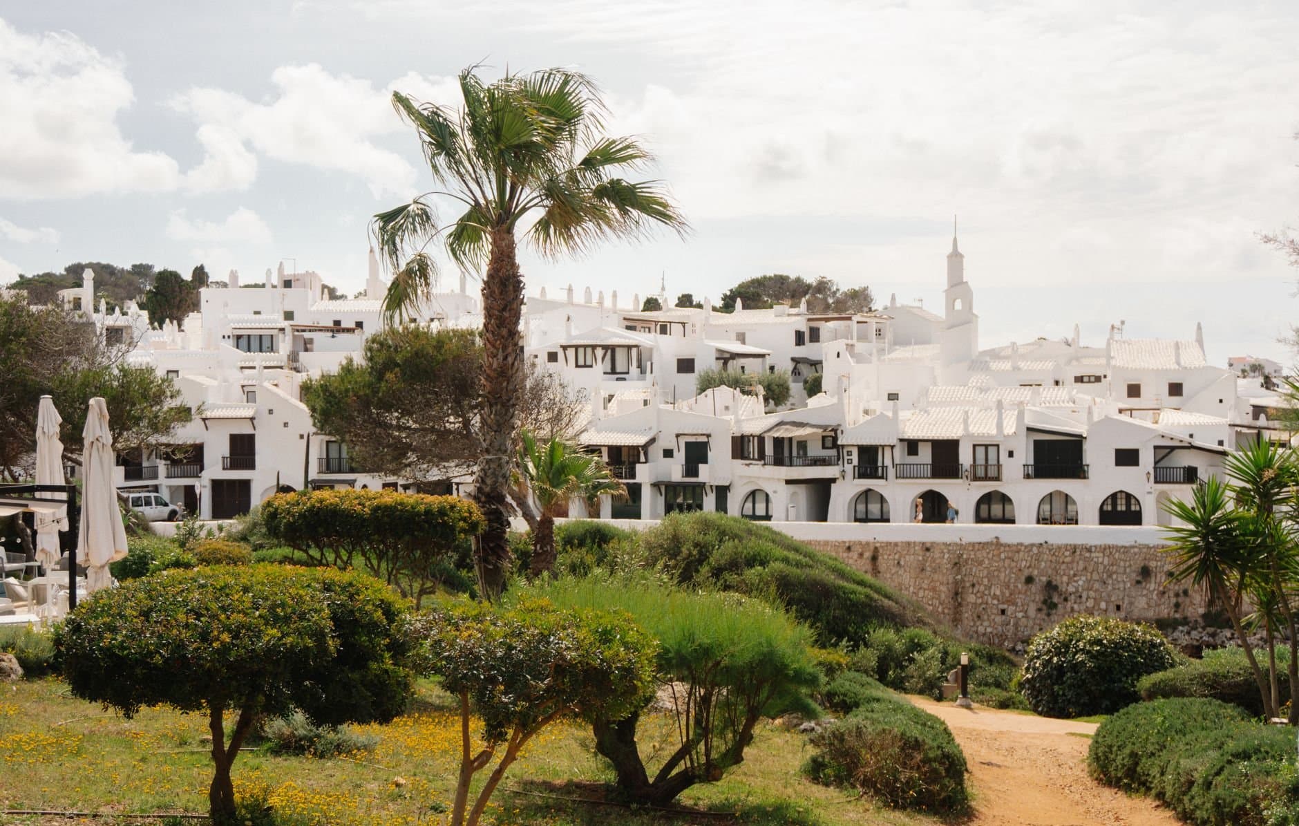 Captivating view of a whitewashed village with lush greenery in Ciutadella de Menorca.