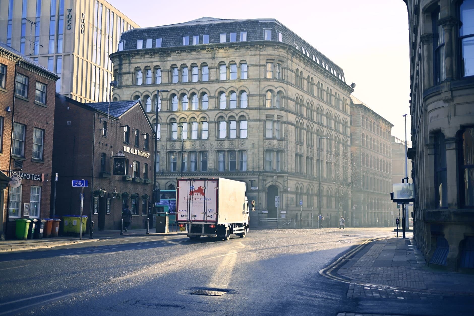 A quiet urban street scene with historic architecture in early morning light.
