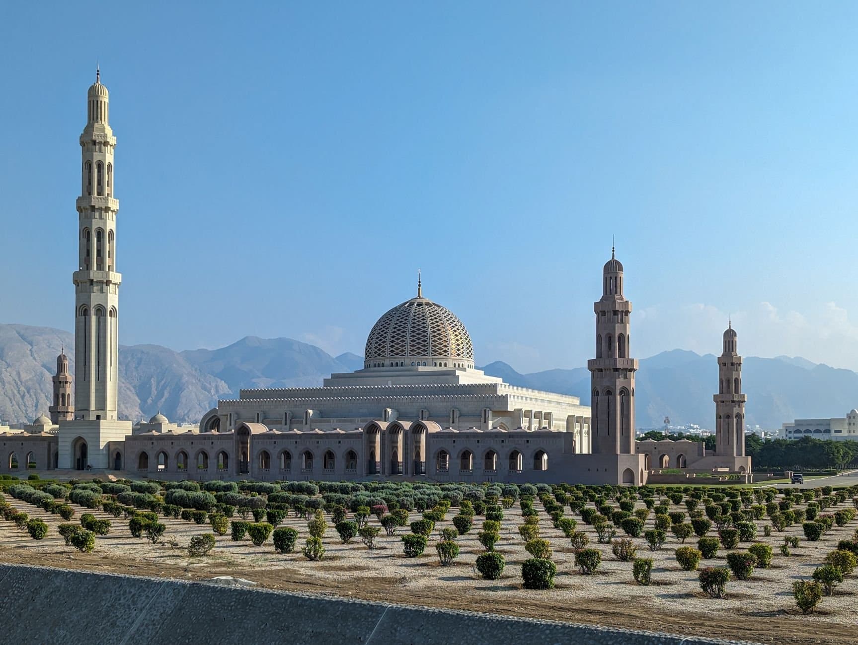 Sultan Qaboos Grand Mosque with its striking minarets against a clear blue sky in Muscat, Oman.