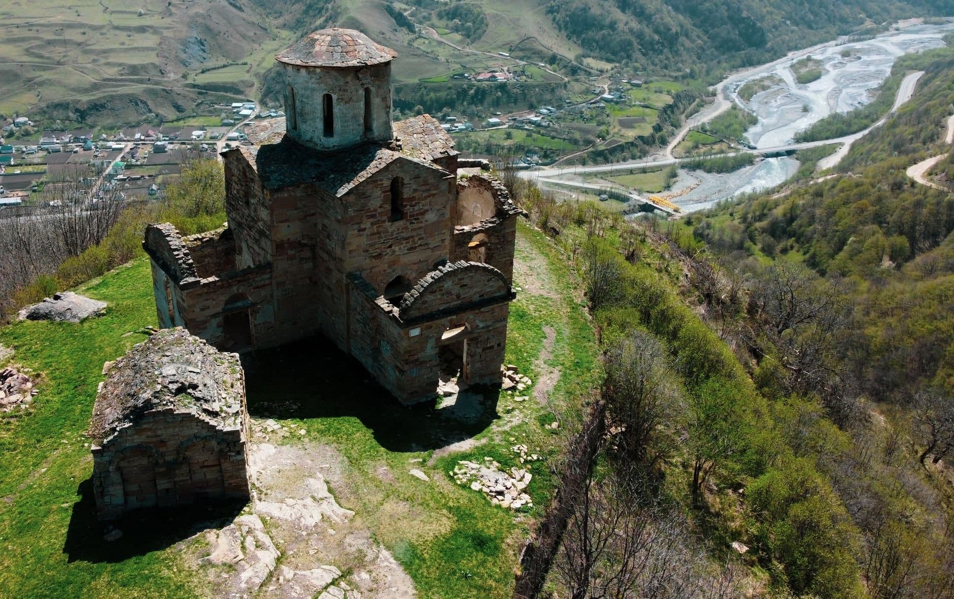 An ancient church atop a hill with scenic views of the river and valley in Karachay-Cherkessia, Russia.
