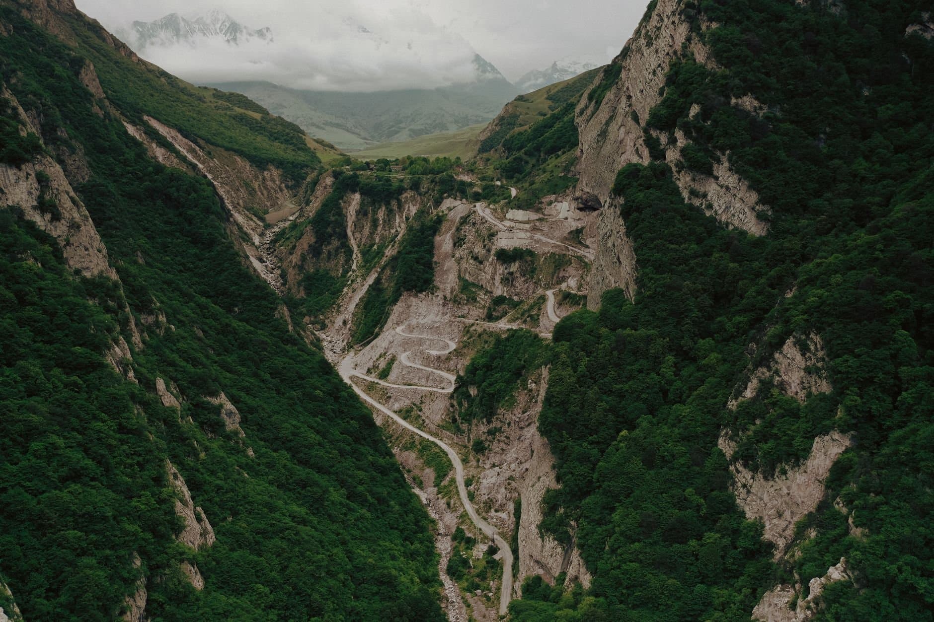 Aerial view of a winding road through green mountains in Dagestan, Russia.