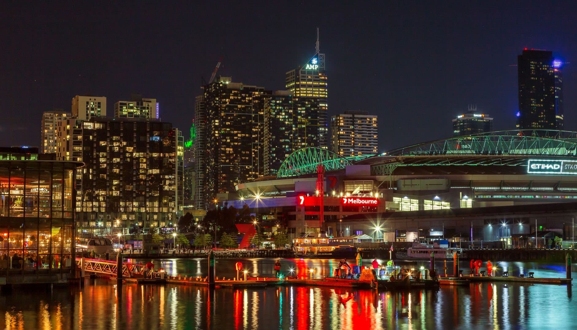 Illuminated Melbourne waterfront cityscape at night showcasing vibrant urban life and architecture.