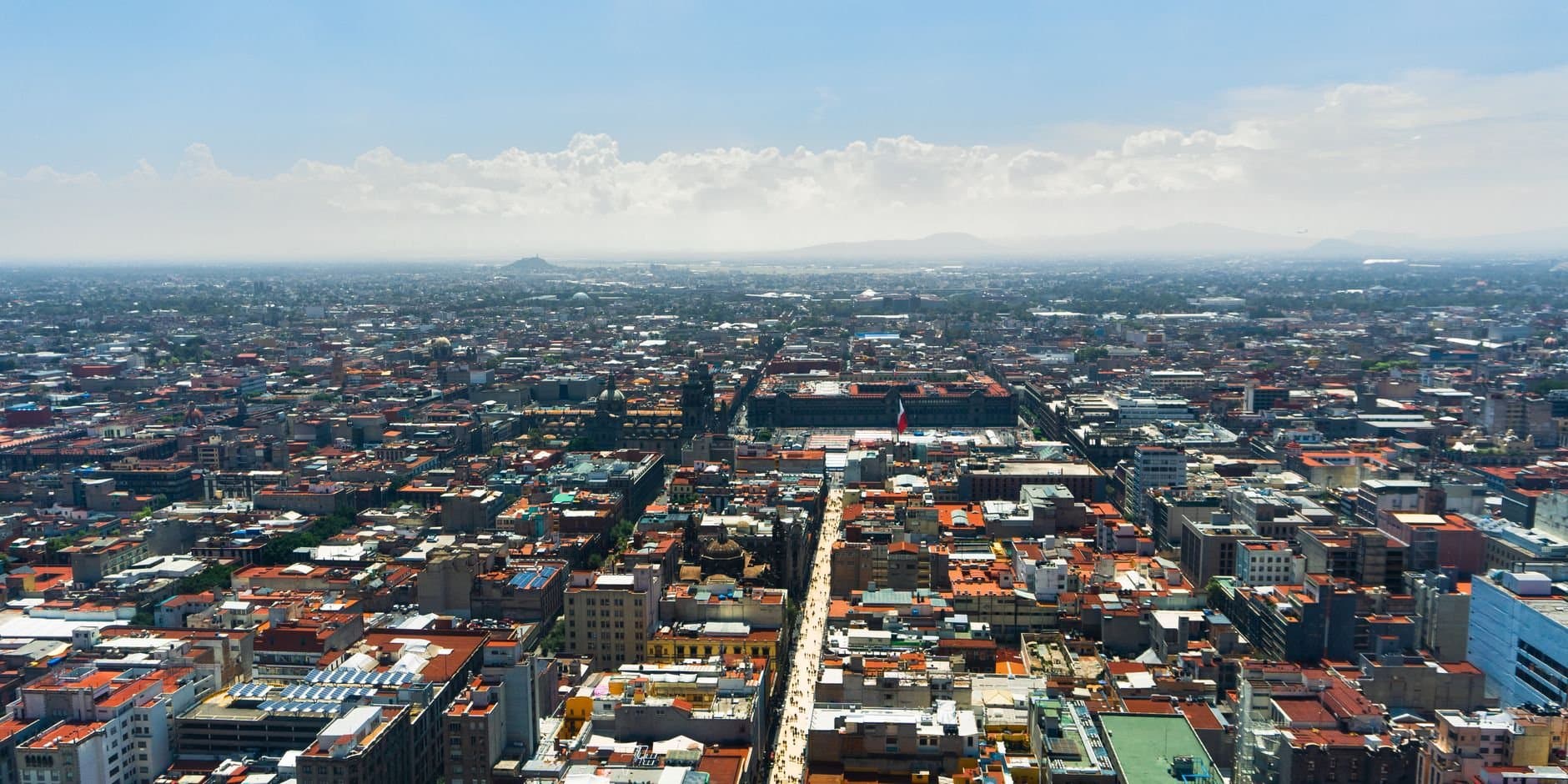 Stunning aerial cityscape of Mexico City under clear blue skies showcasing urban architecture.