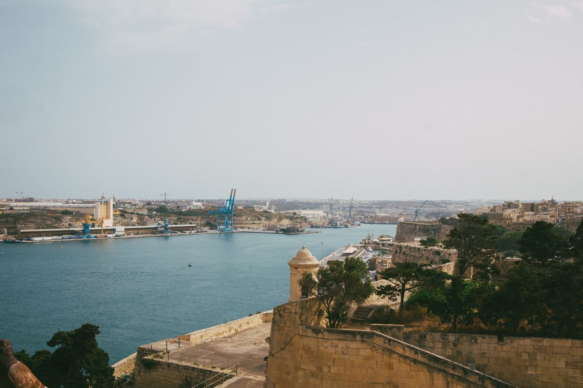 Beautiful view of Valletta harbor showcasing historic architecture and blue waters under an overcast sky.