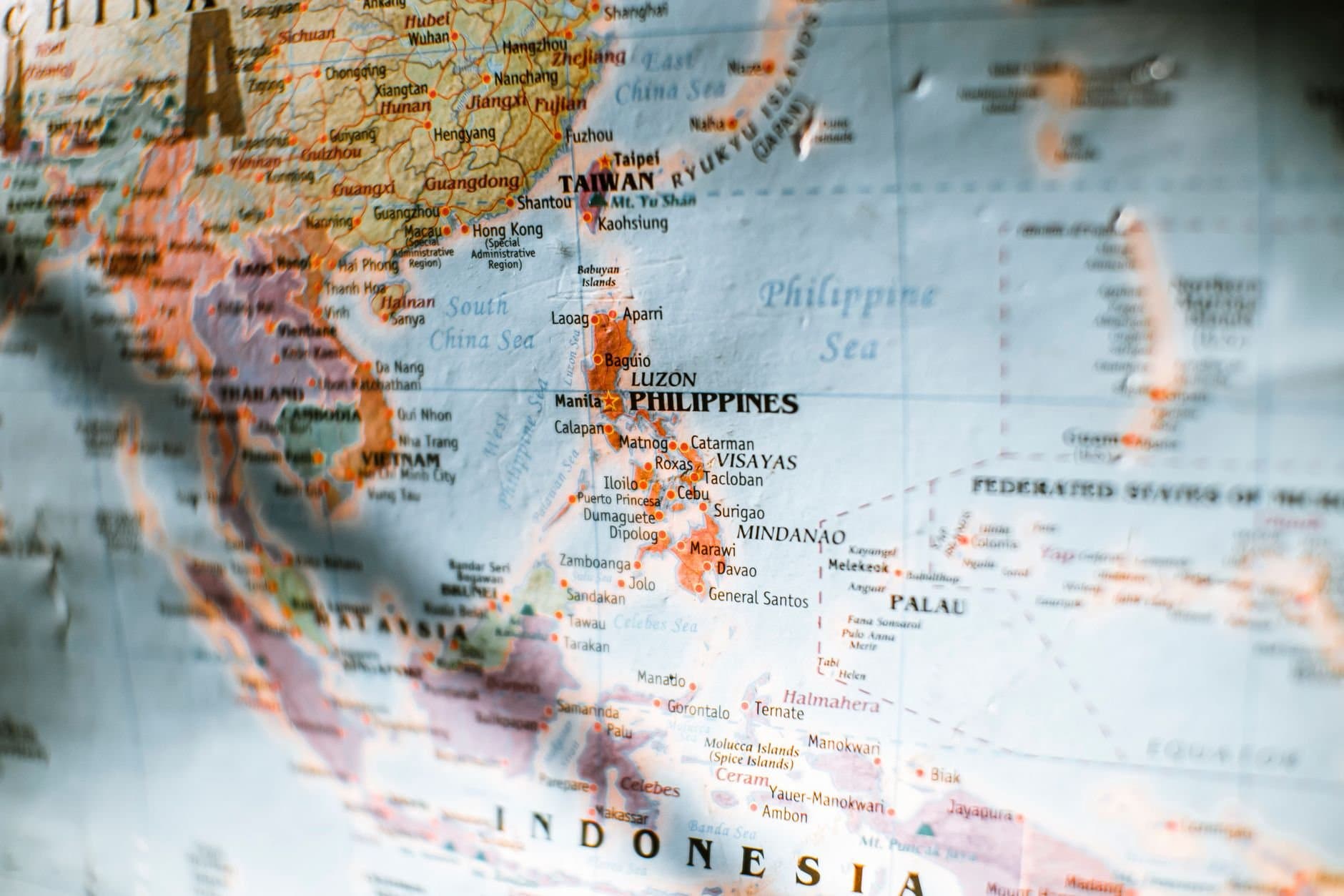 Closeup of paper world map with selective focus of Philippines surrounded by seas