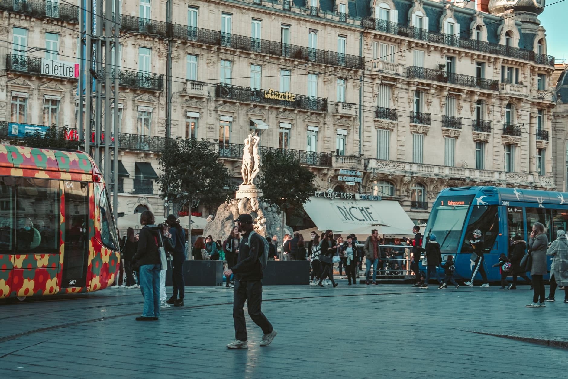 Vibrant street view in Montpellier with colorful trams and classic architecture.