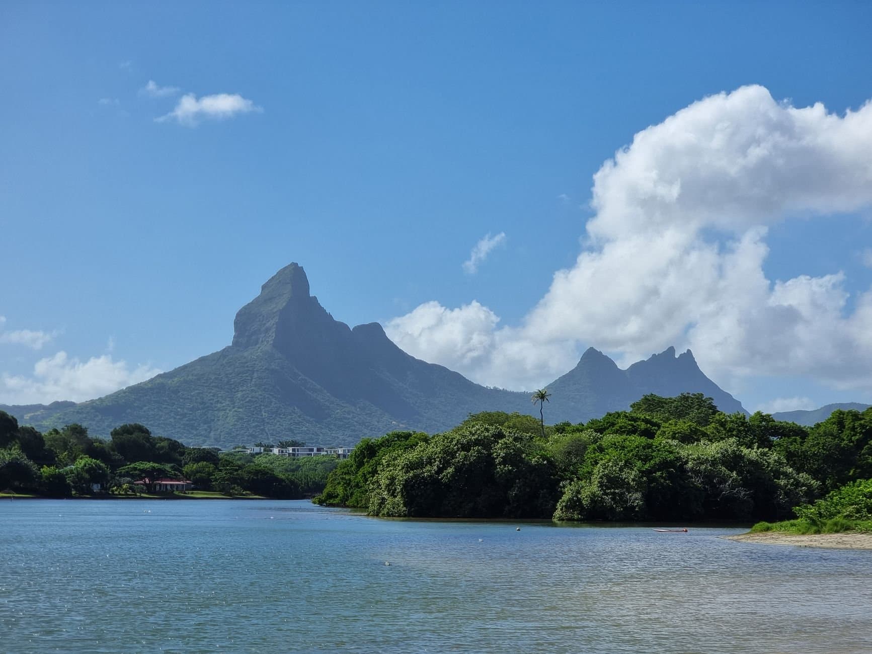 Capture of Mauritius' iconic mountains and lagoon under clear blue sky.