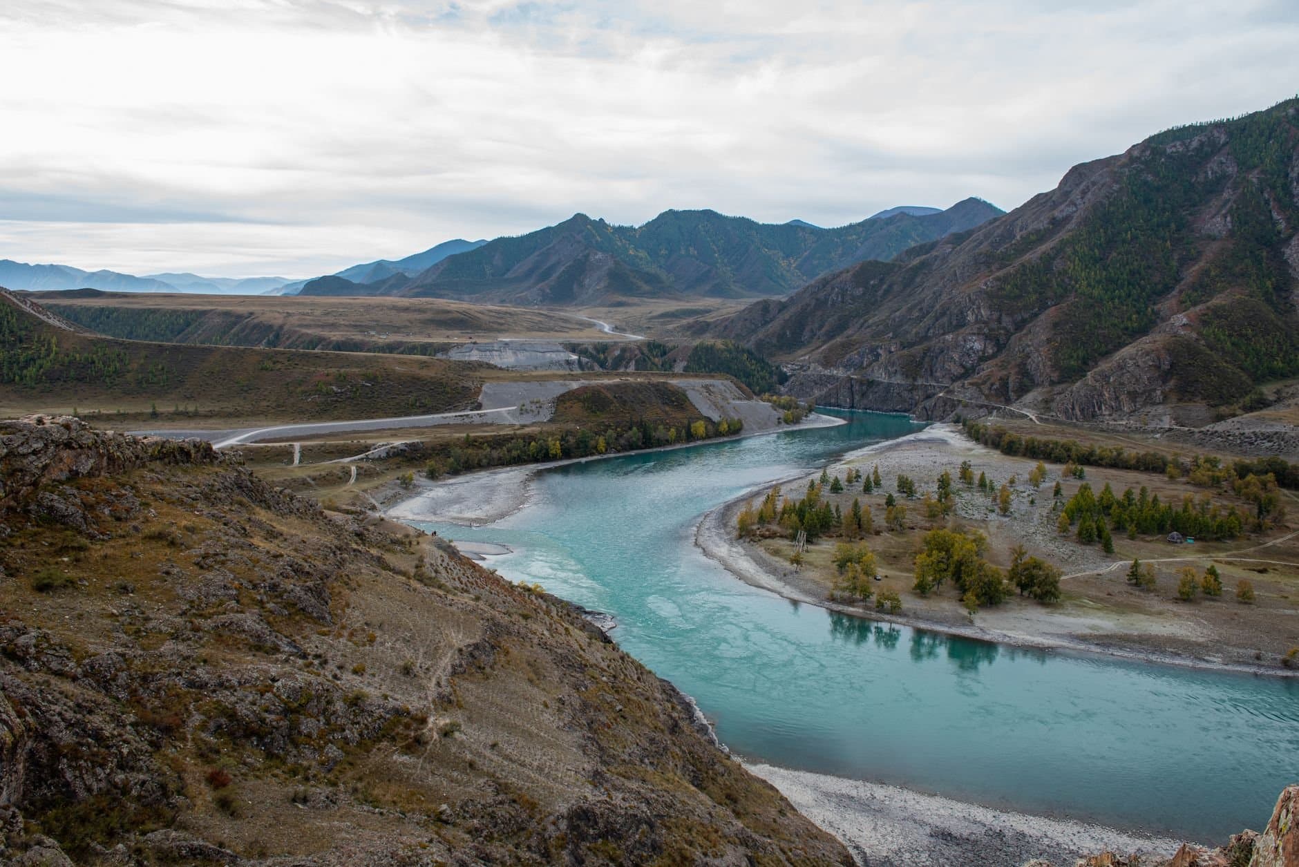 A breathtaking view of the winding river and mountains in Altai, Russia, capturing nature's serene beauty.