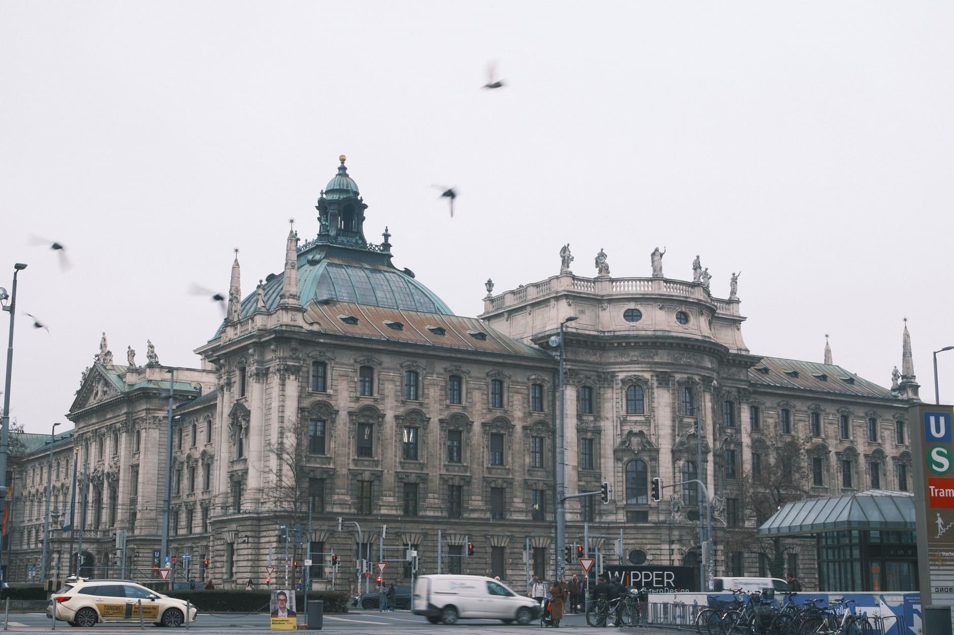 Majestic old architecture building in Munich with urban street scene on a cloudy day.