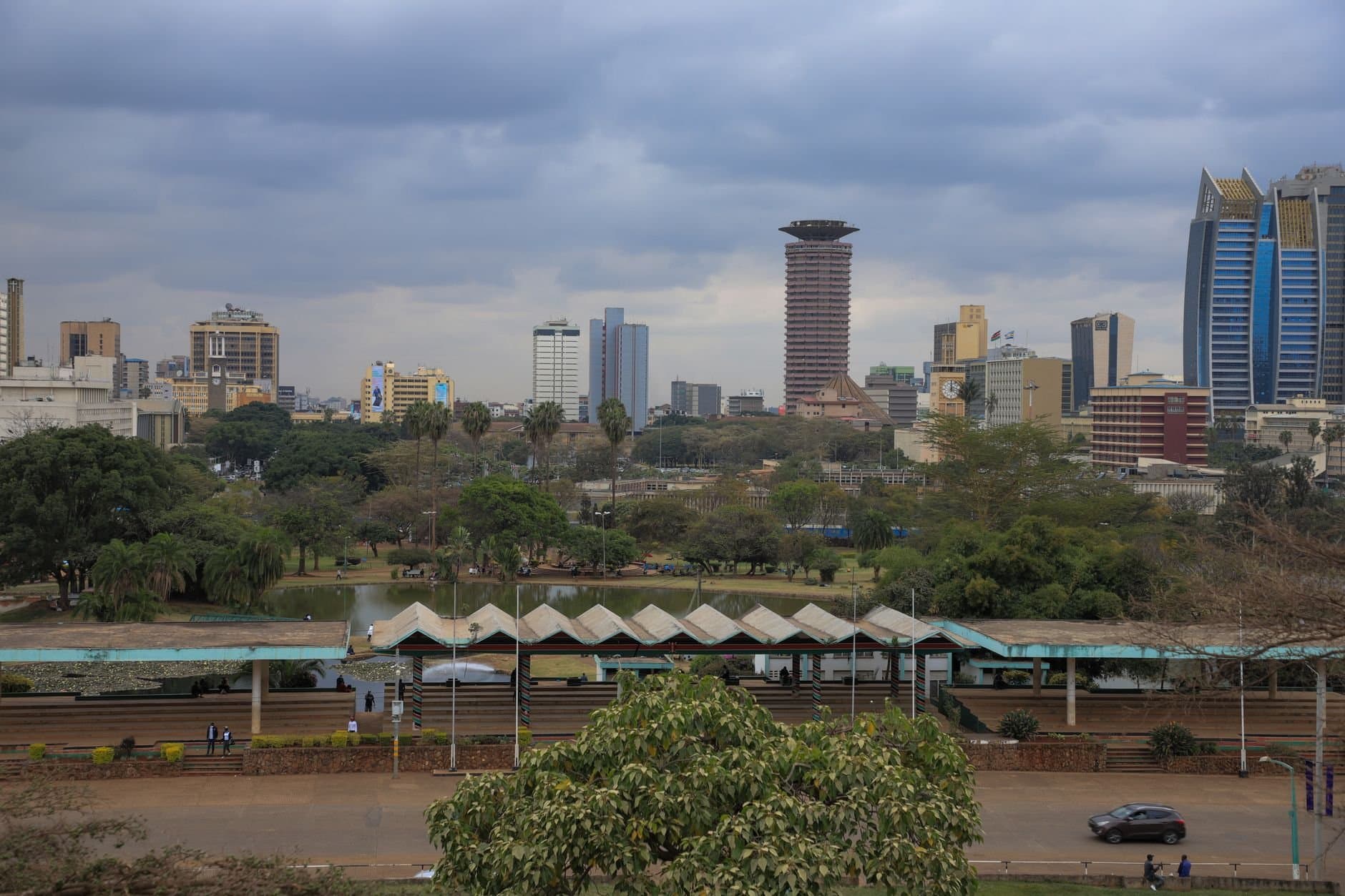 Nairobi cityscape featuring modern skyscrapers and lush greenery on a cloudy day.