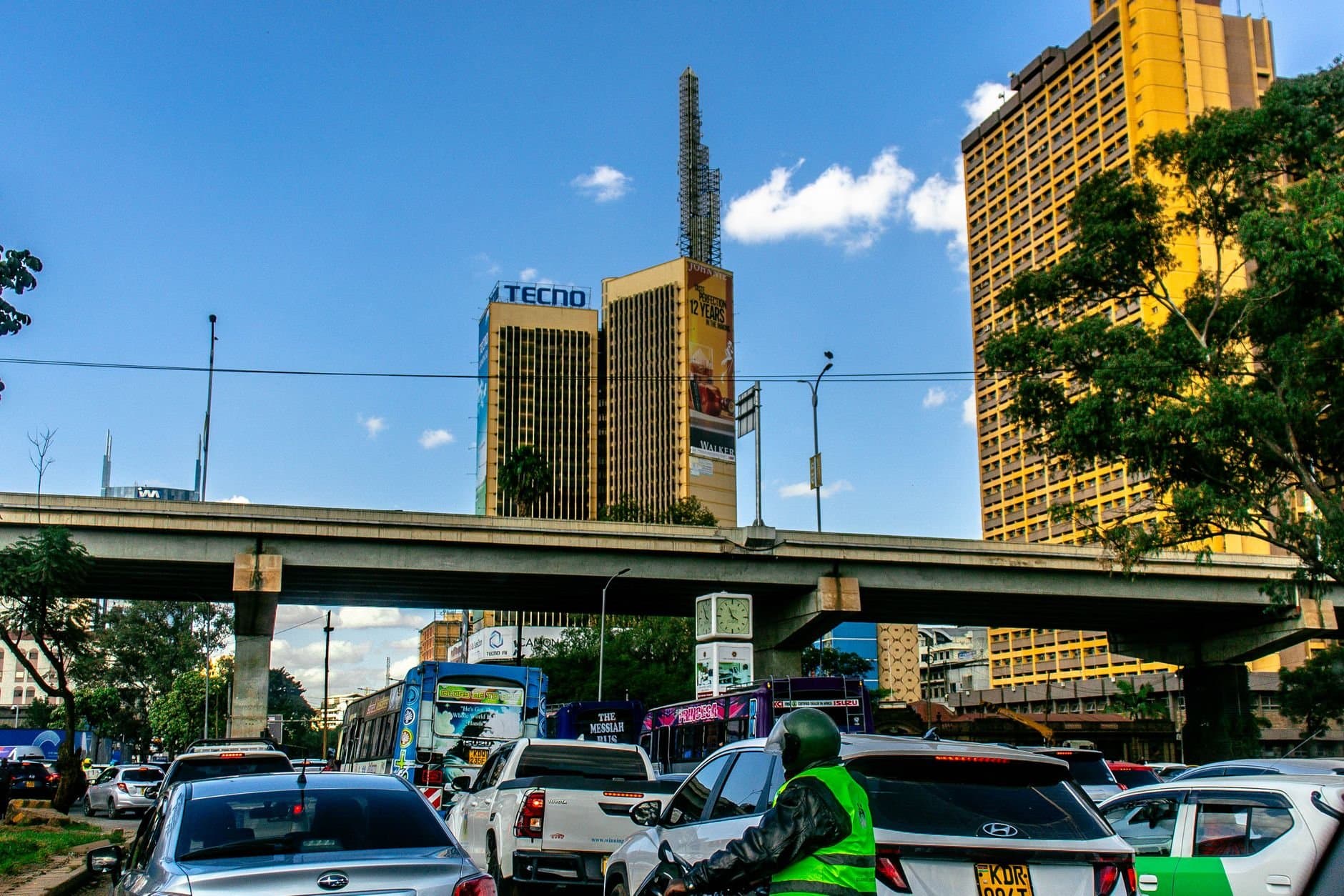 Street scene with traffic and tall buildings in Nairobi, Kenya on a clear day.